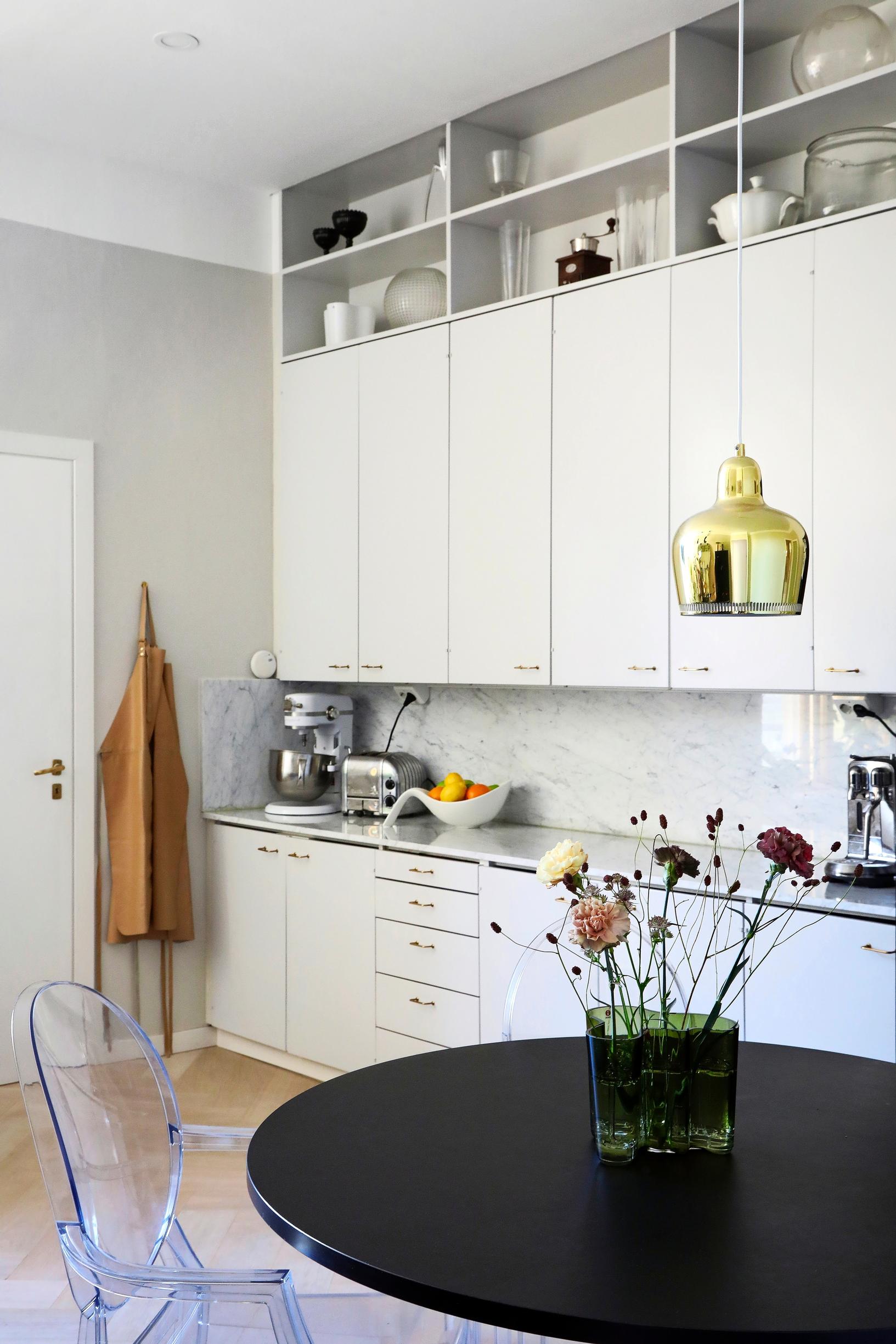 White open-plan kitchen with a black table