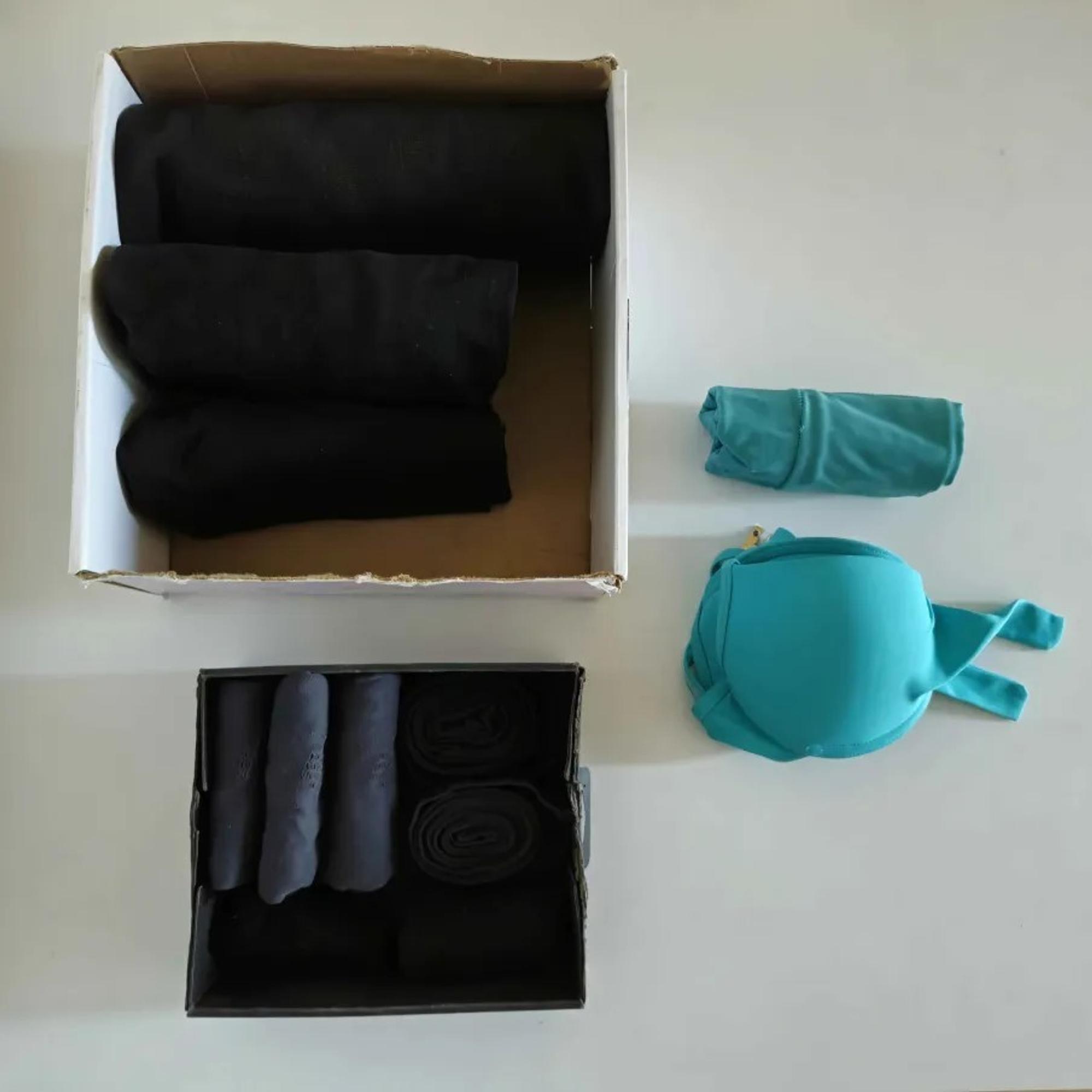 two cardboard boxes containing black clothes