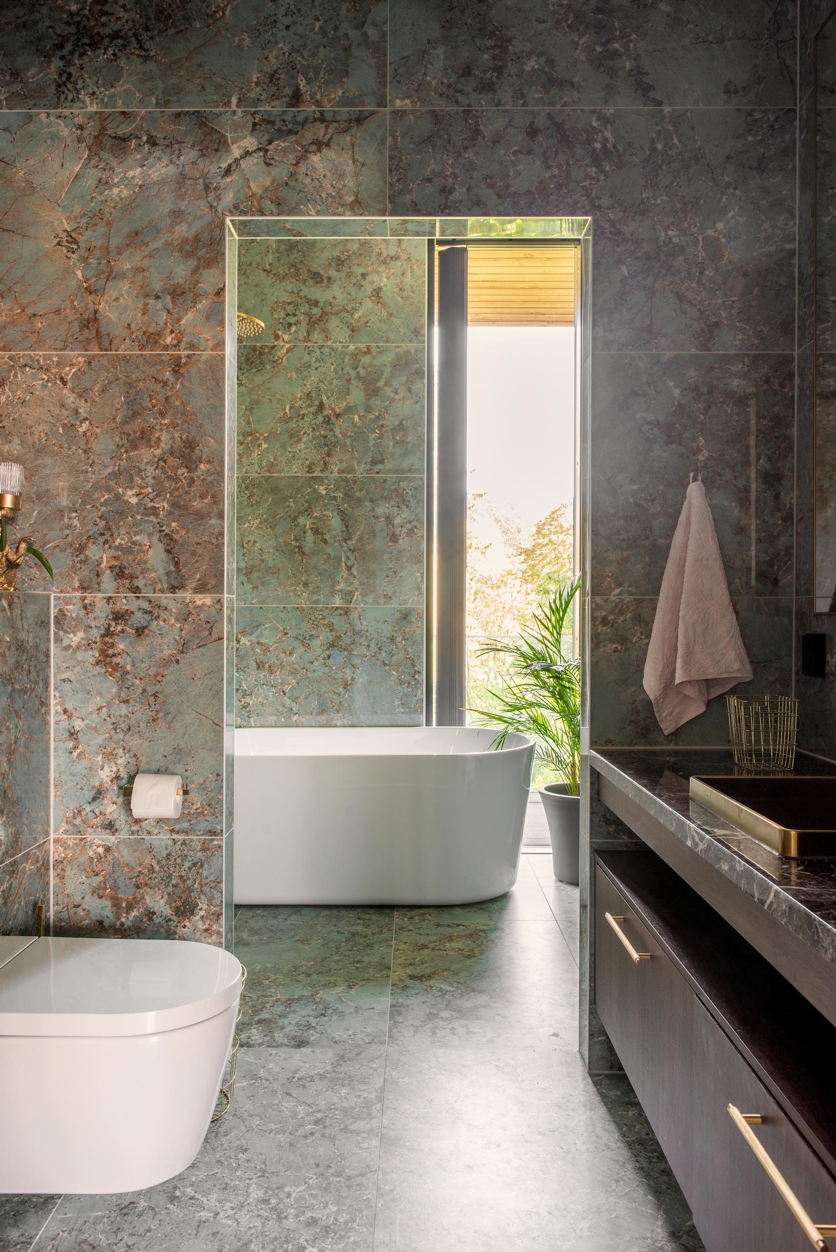 At the far end of the bath area, a tub and a window