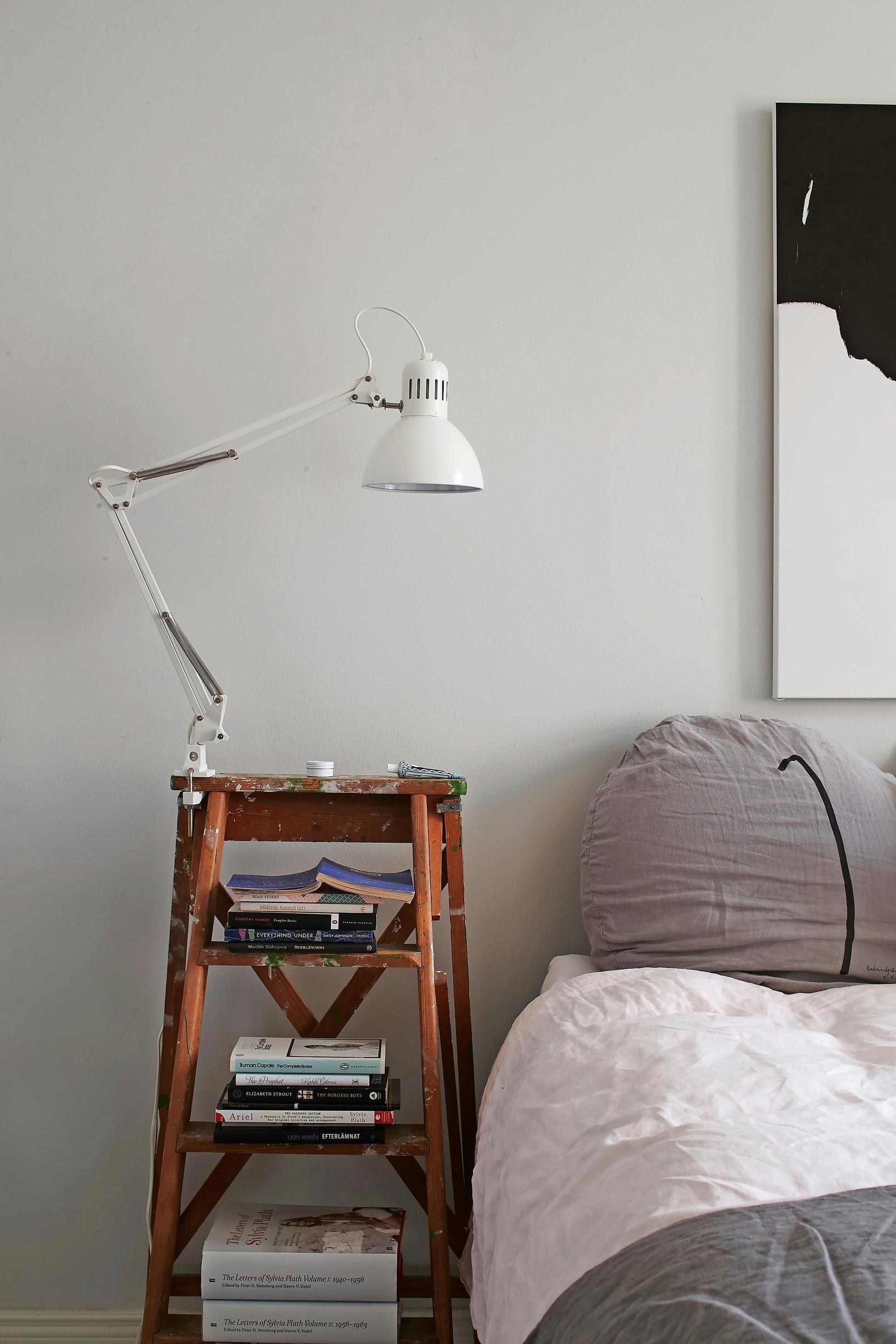 A painter’s ladder used as a nightstand.