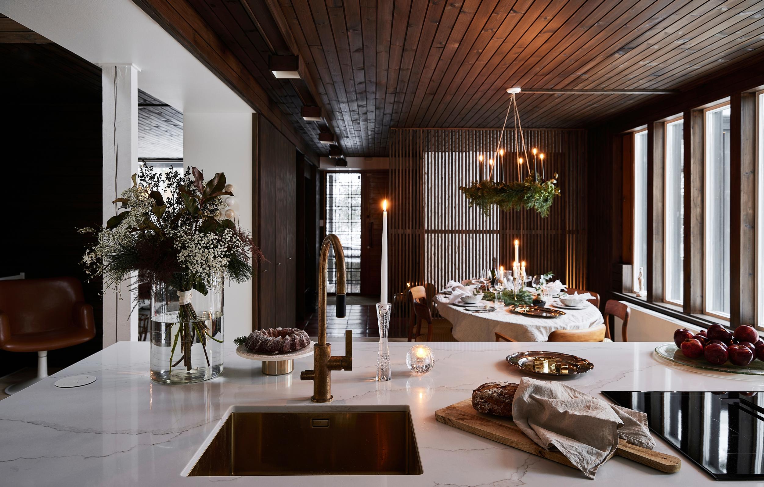 In the kitchen, marble-patterned quartz countertops with the dining area in the background.