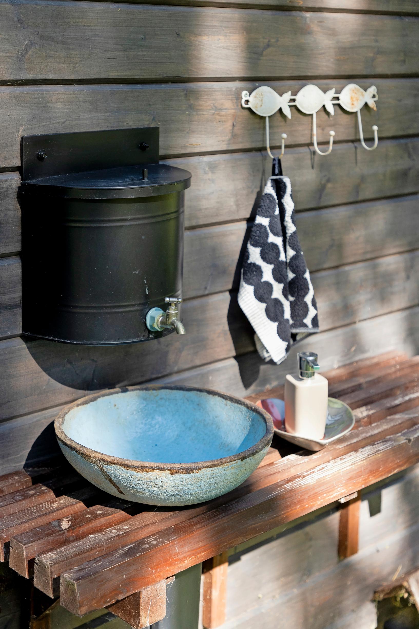 A ceramic basin made by Marita and a metal water container at the wash station