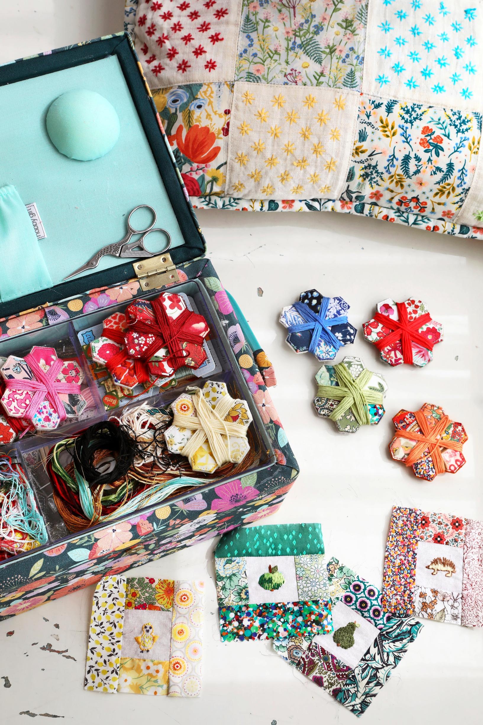 Thread spools and colorful patches in and next to a box