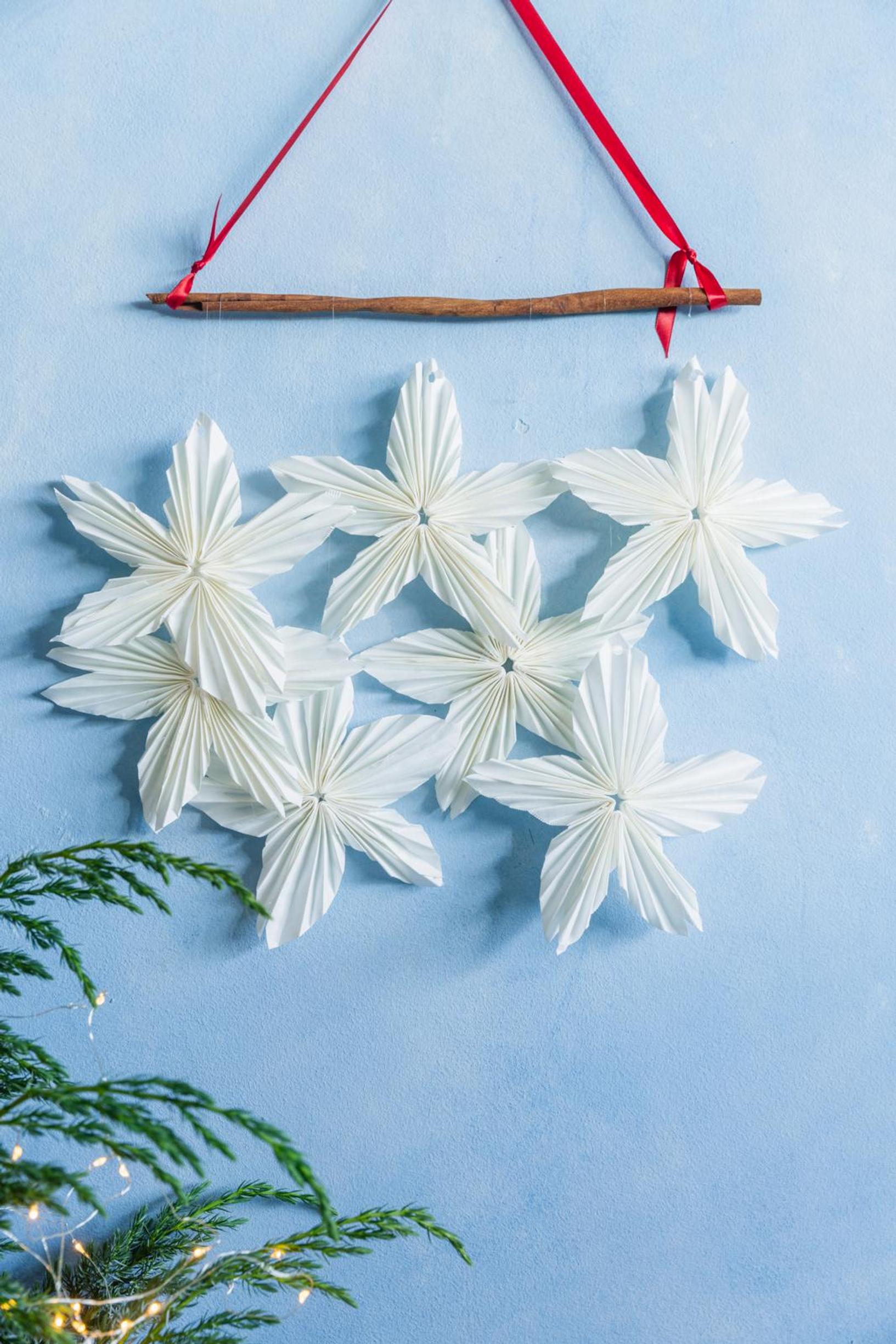 Coffee filter stars attached to a cinnamon stick and hung on the wall.
