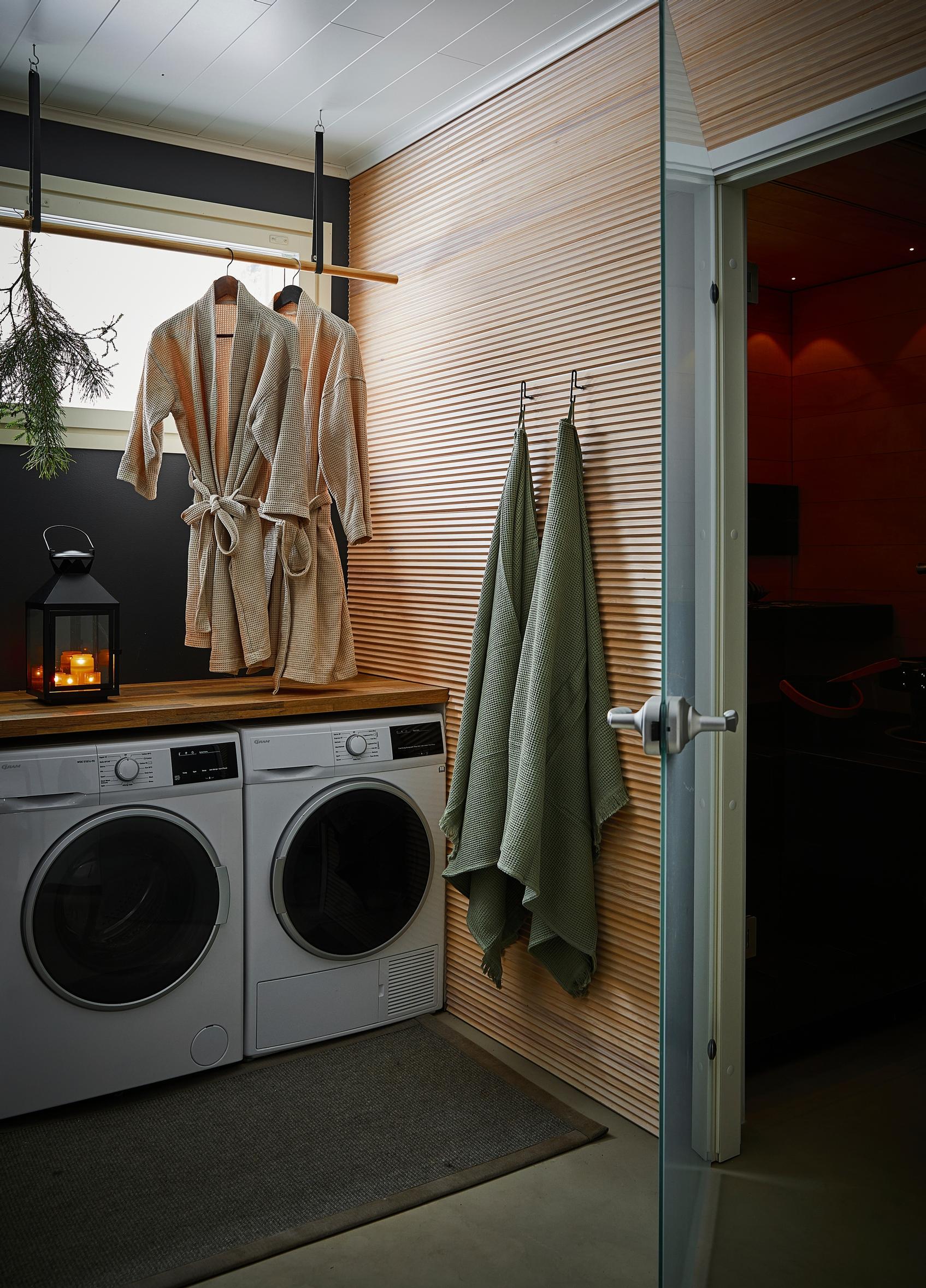 in the bathroom: washing machines, bathrobes, towels, and a lantern