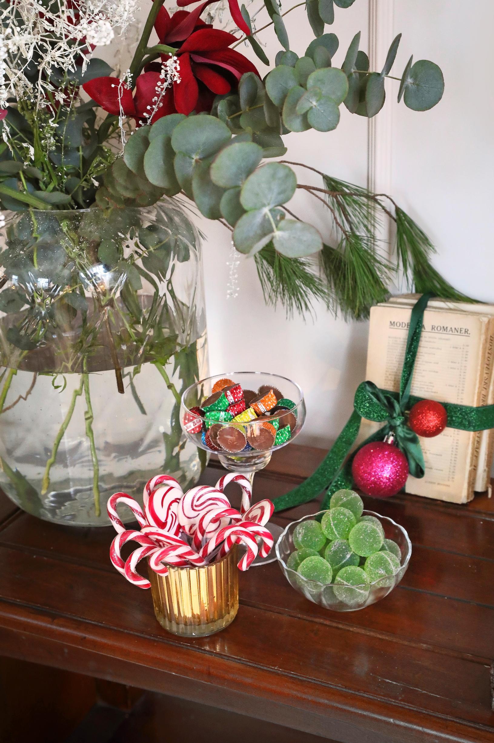 Green marmalade candies, candy canes, and other Christmas treats on top of a dresser