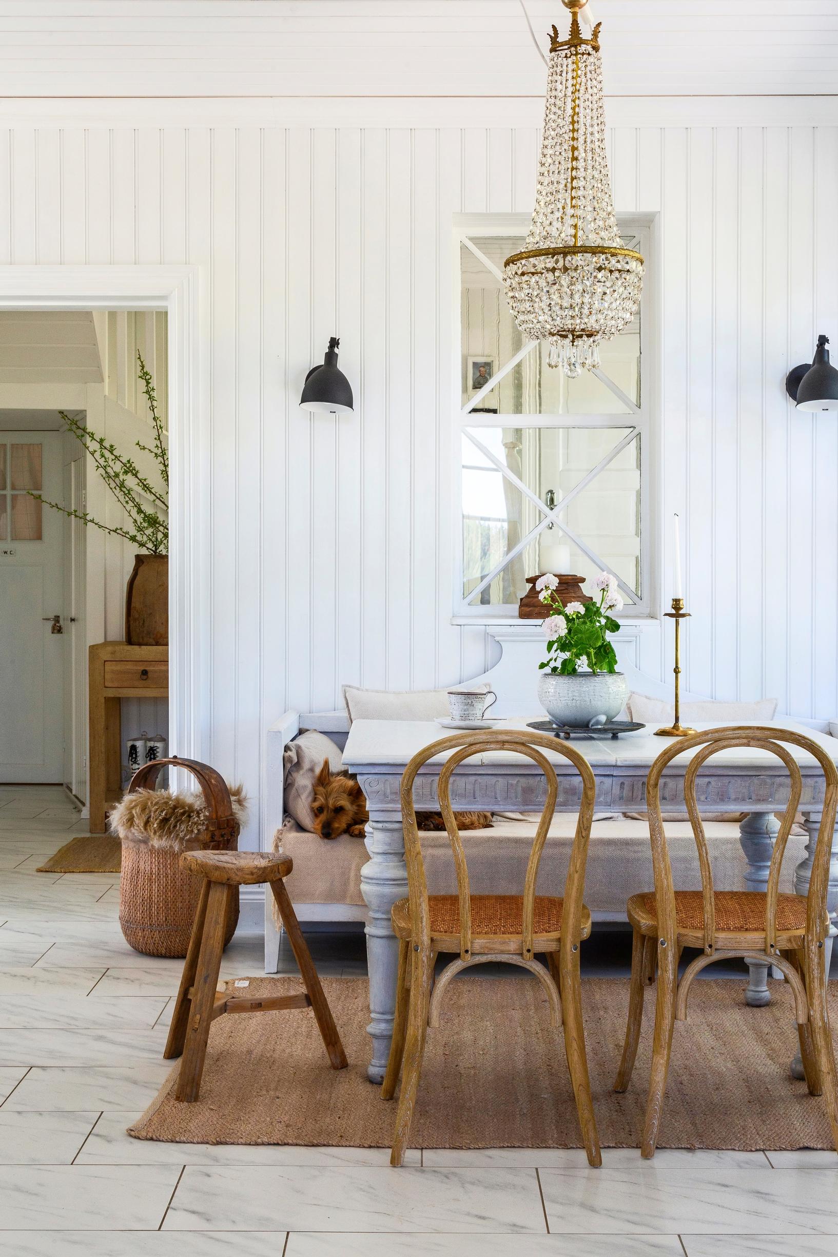Dining area with a Gustavian-style sofa and a turned leg table with wooden chairs