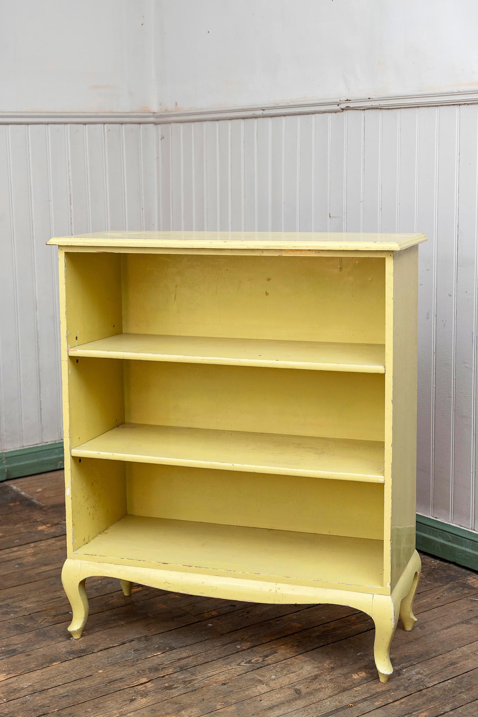 A vintage yellow open shelf is upcycled with wallpaper and linseed oil paint into a shoe shelf, step-by-step photo.