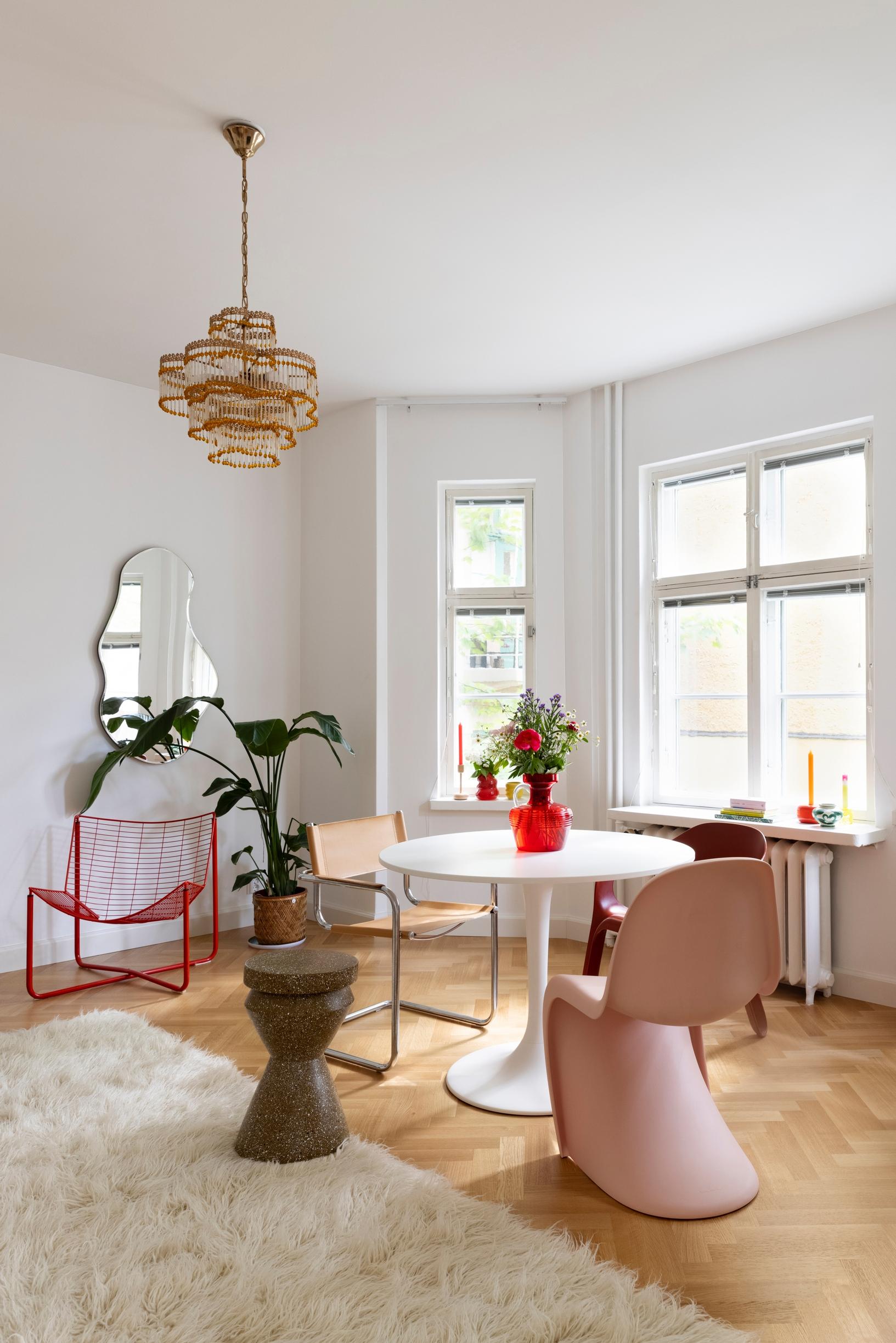 A dining table and mismatched chairs in front of a spacious bay window.
