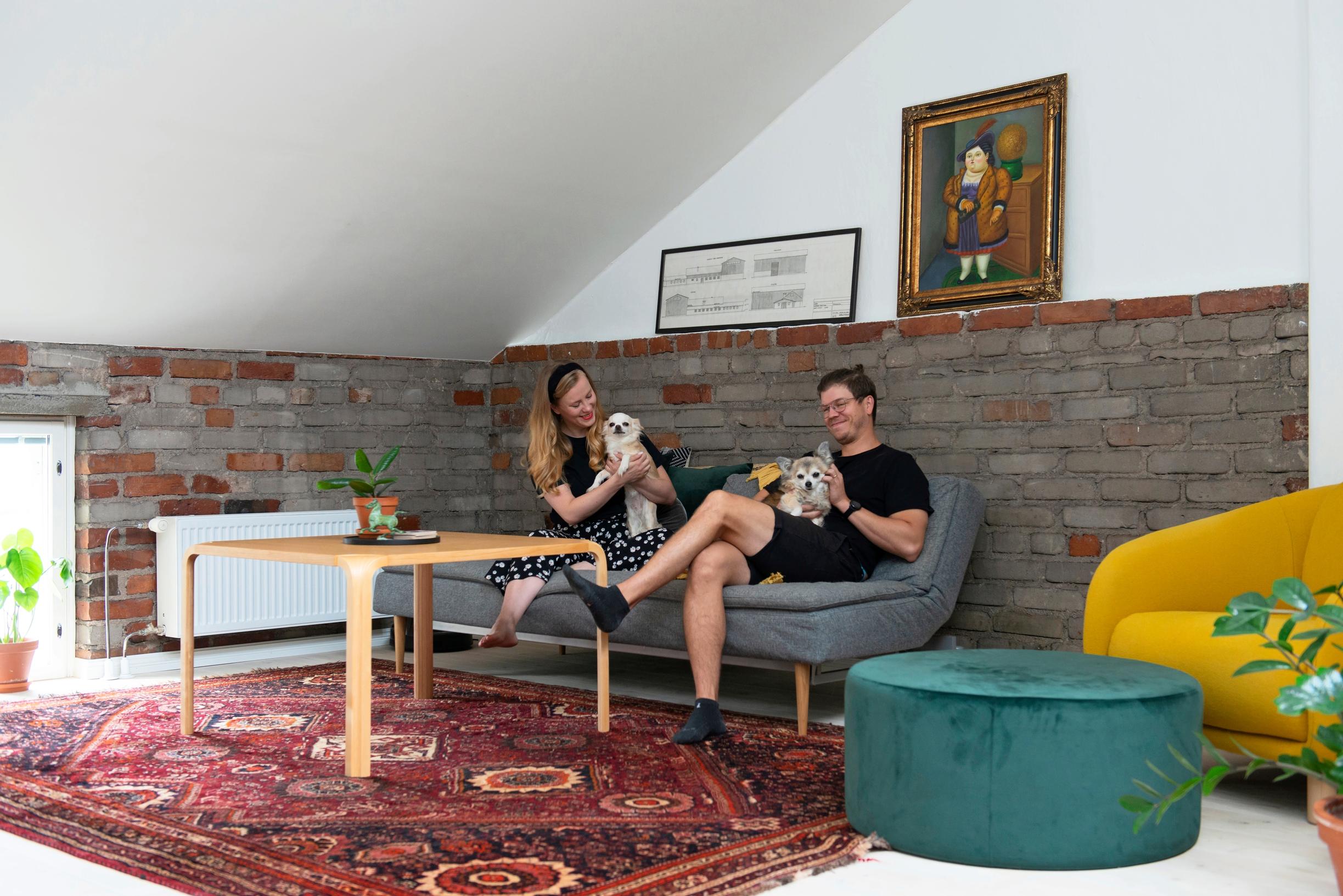 Photo of the couple in the living room with an Artek coffee table and vintage furniture.