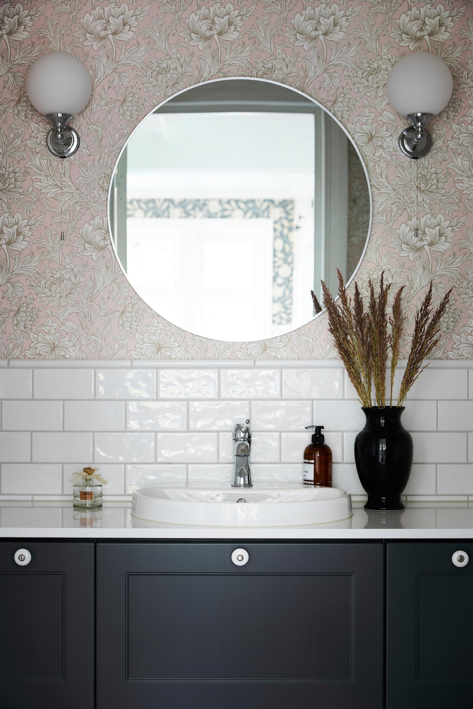 White, glossy, brick-laid tile and floral wallpaper in the bathroom
