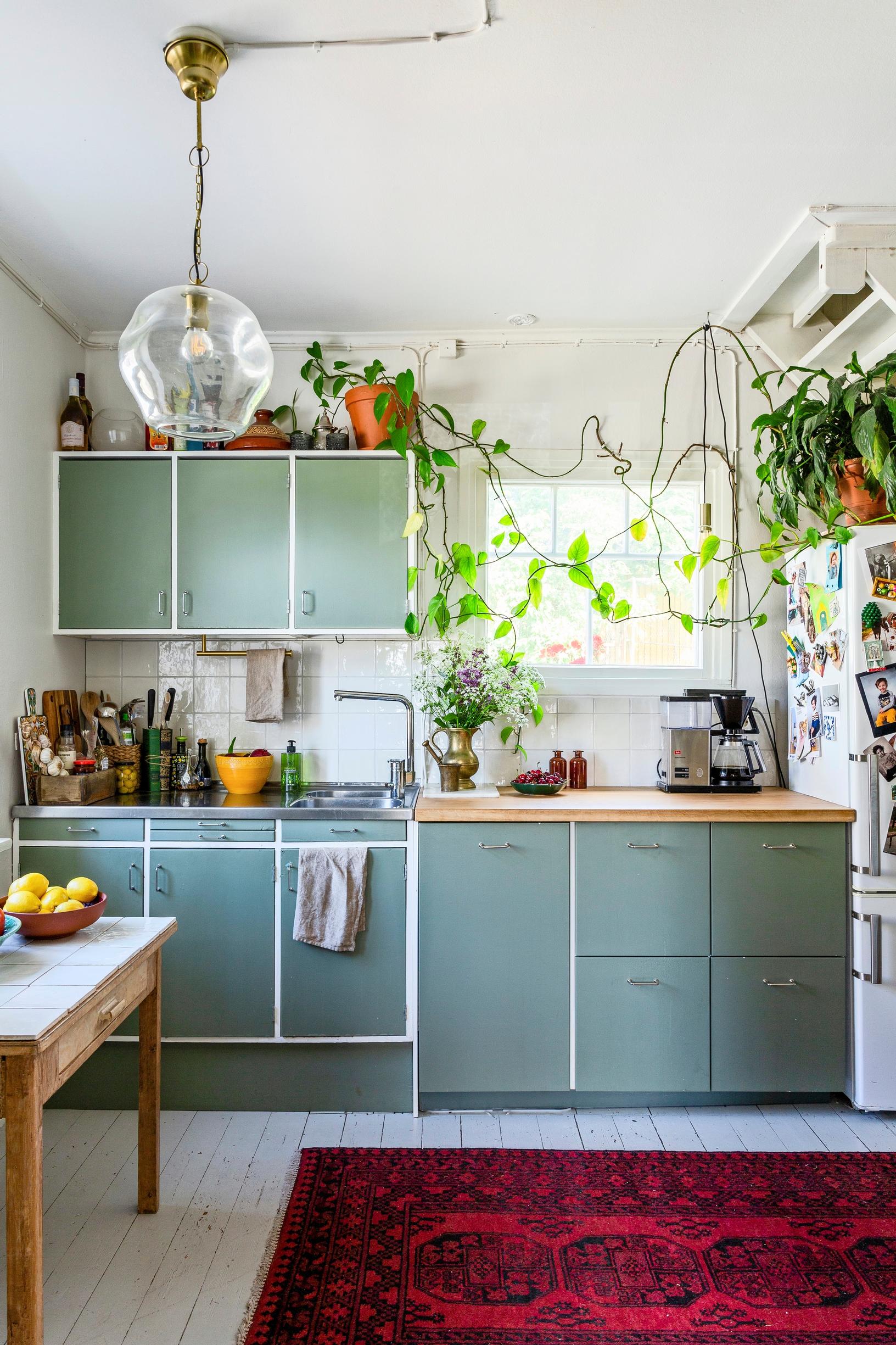 An old house kitchen featuring green-toned 1950s cabinets