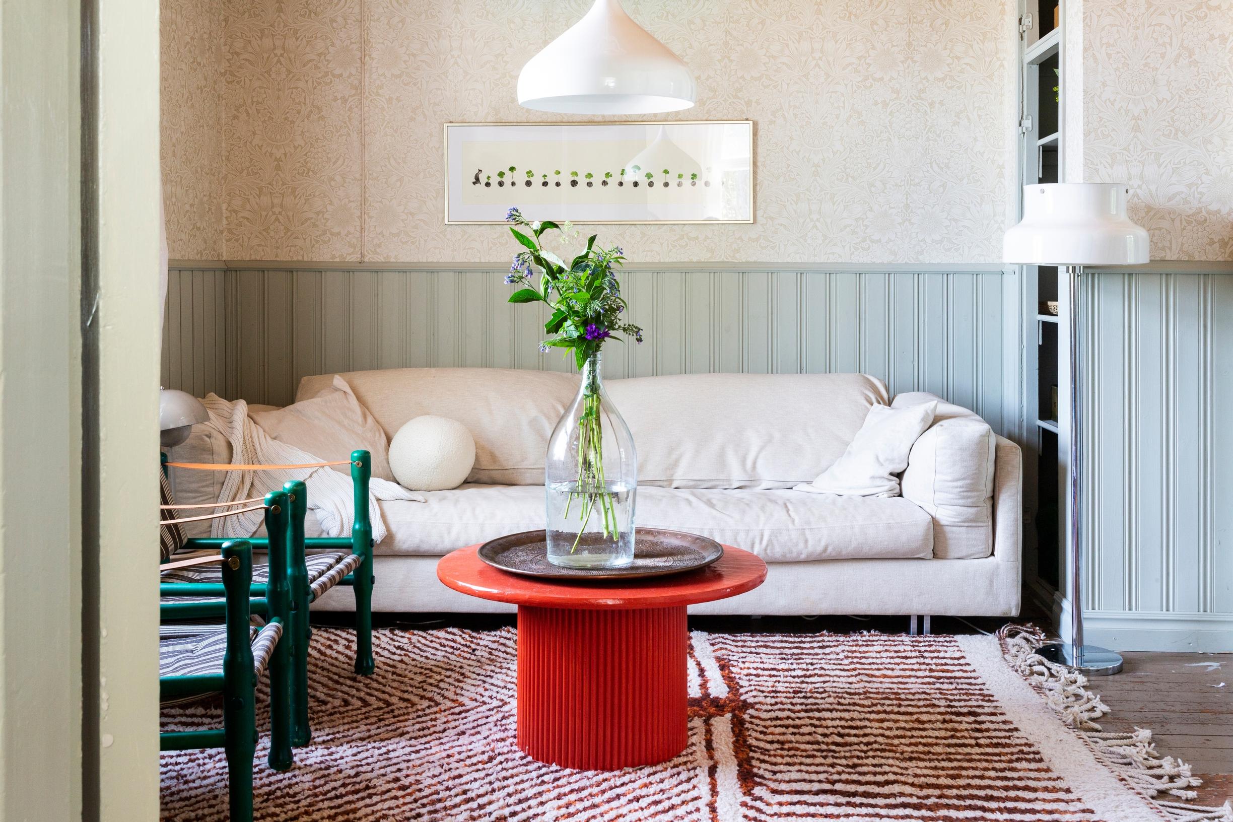 Red table and white sofa in the TV room.
