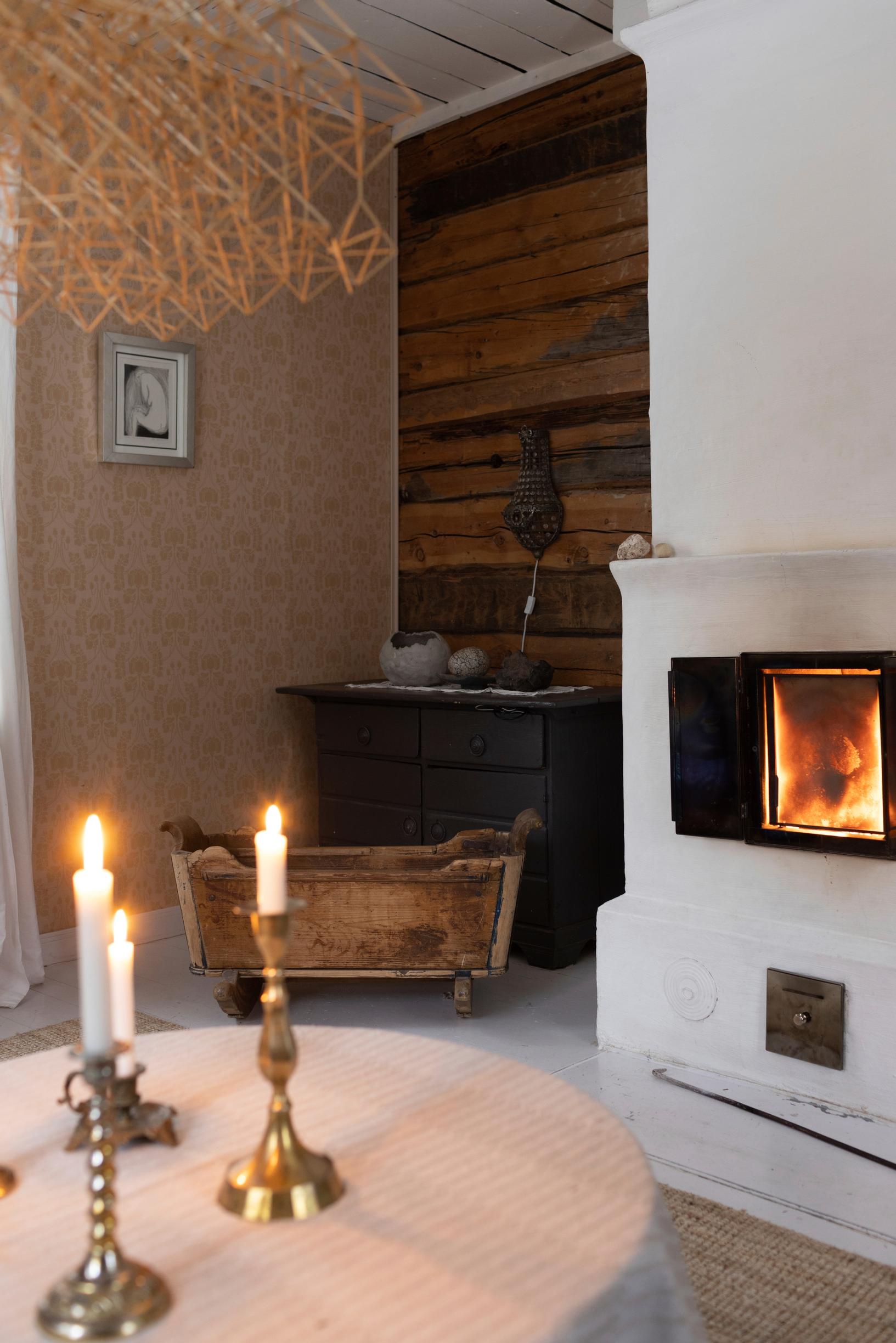 A fireplace in the living room with beige wallpaper.