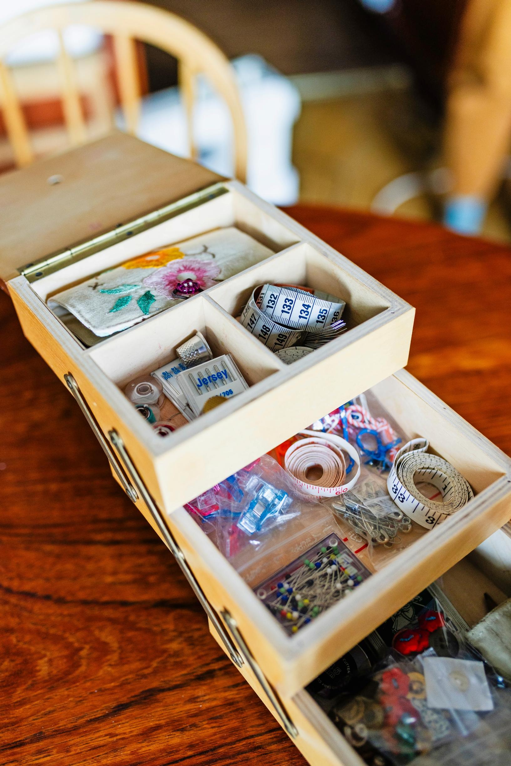 A wooden box filled with sewing supplies.