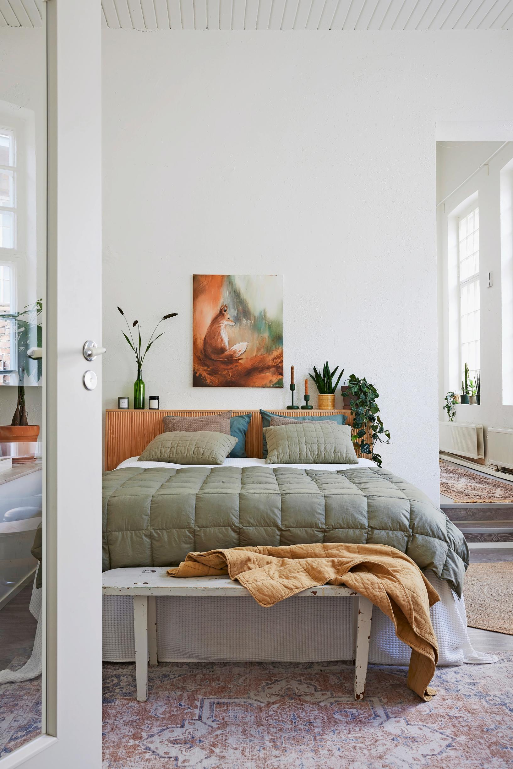 a green bedspread in the bedroom