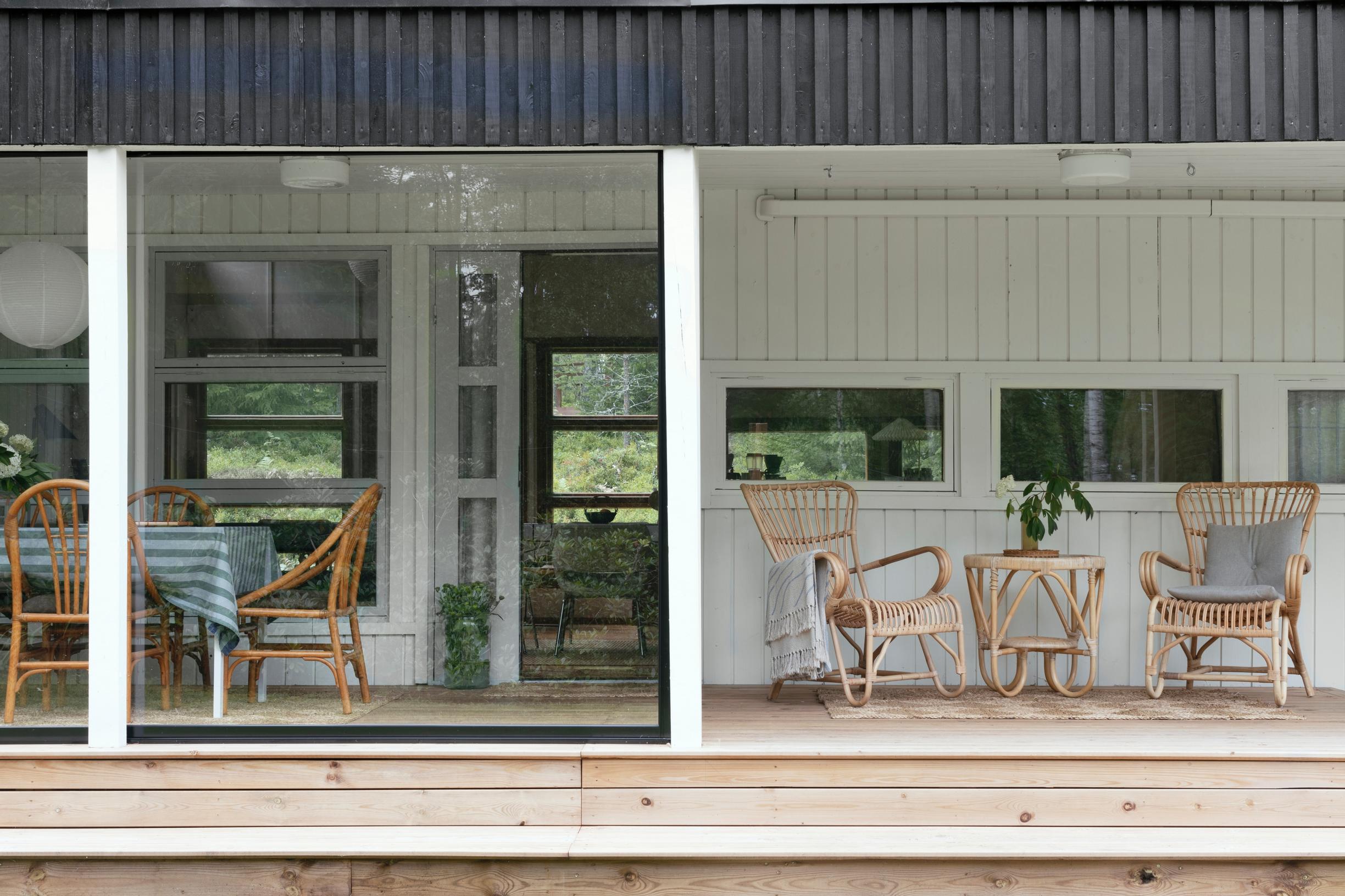 Two rattan table sets on the glazed terrace of the cottage.