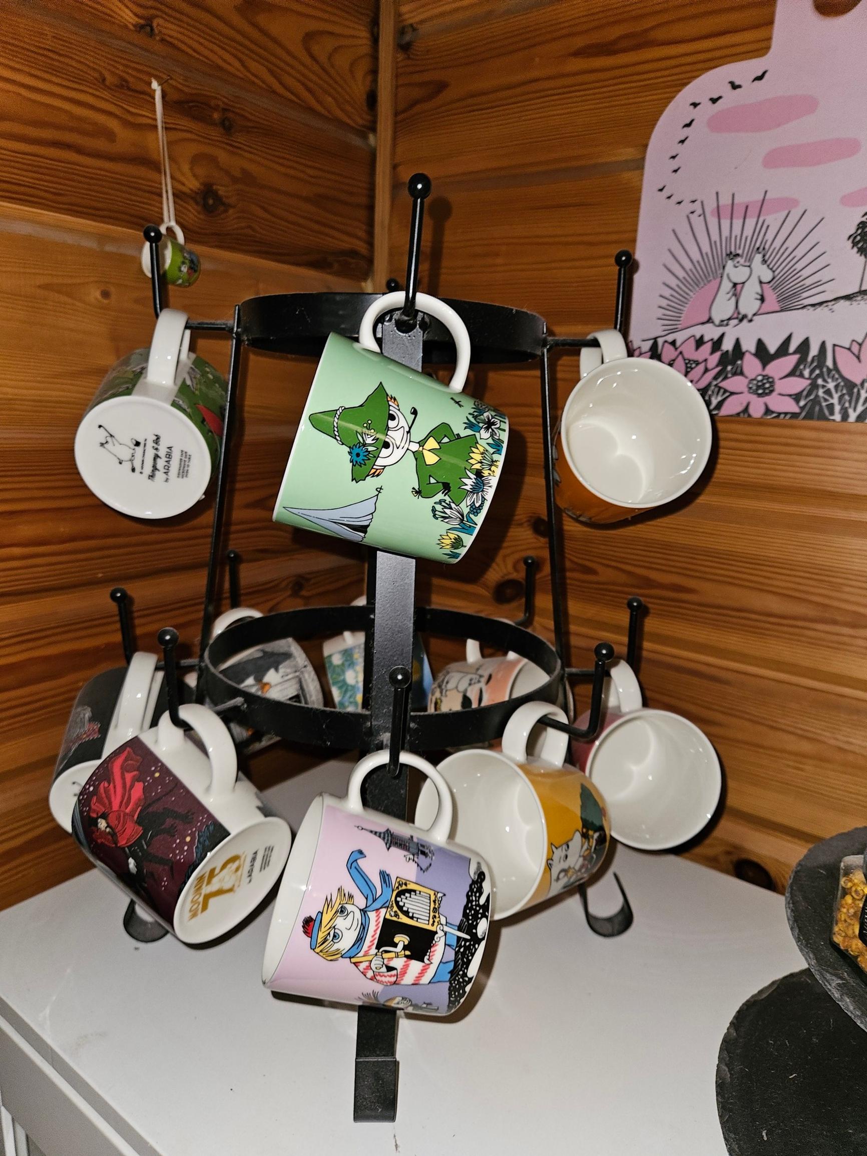 Moomin mugs hanging on a rack on the table