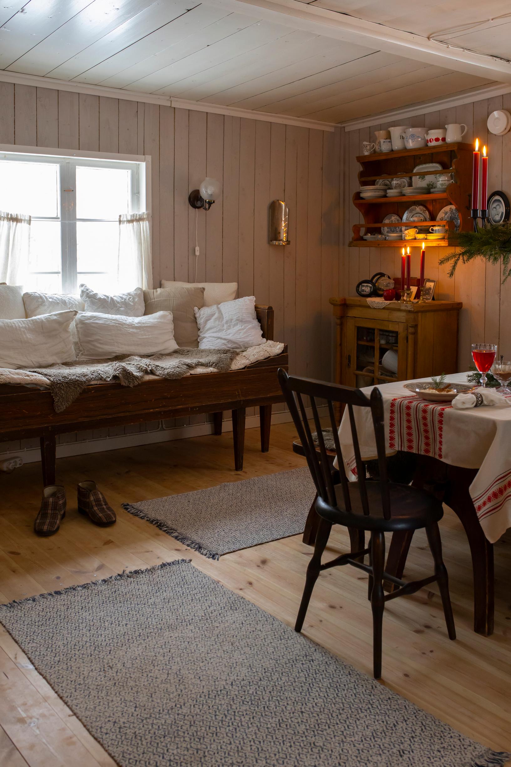 A wooden sofa, a dining set, a cupboard, and candles.