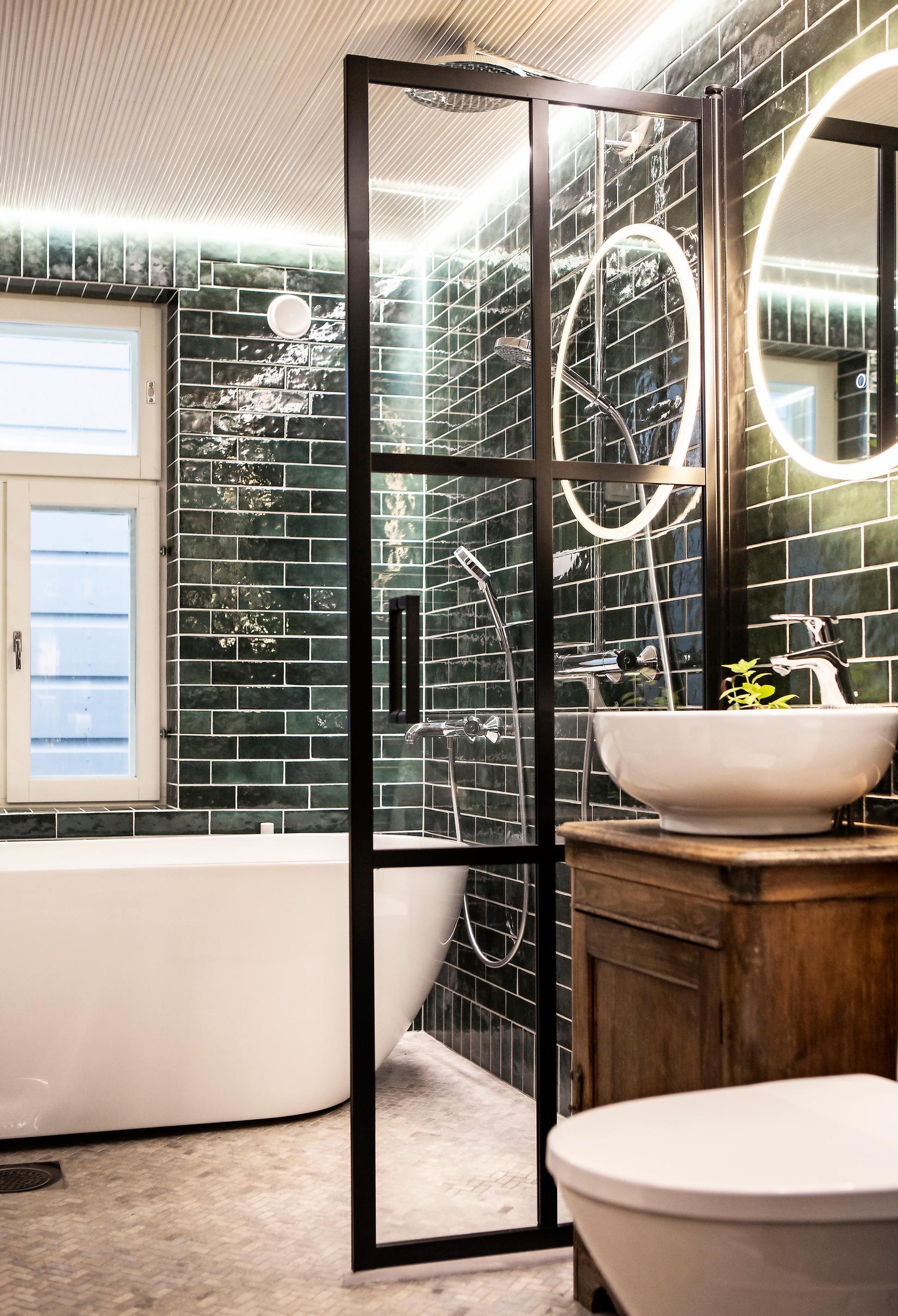 Green and white bathroom. Green tiles laid in subway style on the walls.