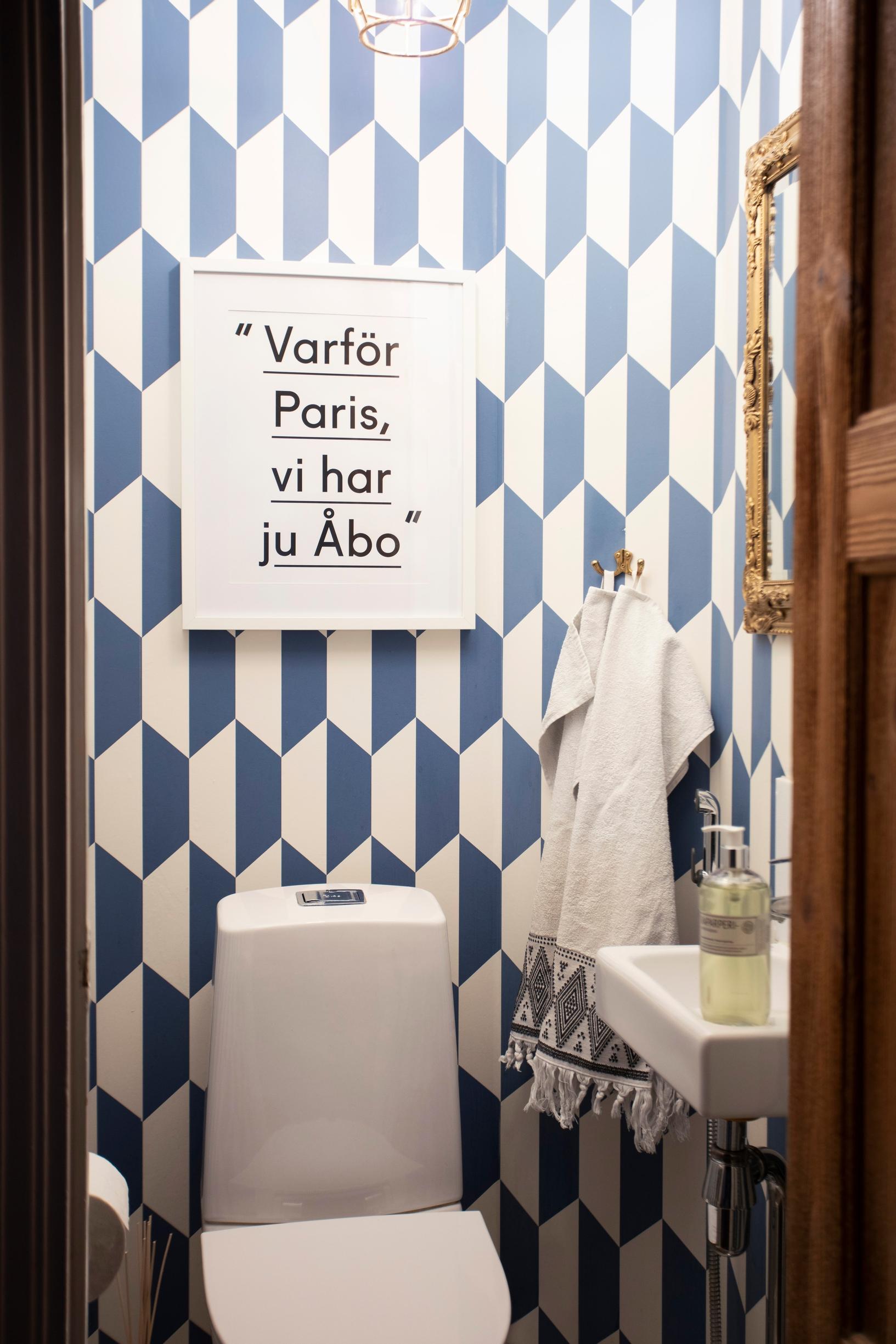 Blue and white wallpaper in a small bathroom.