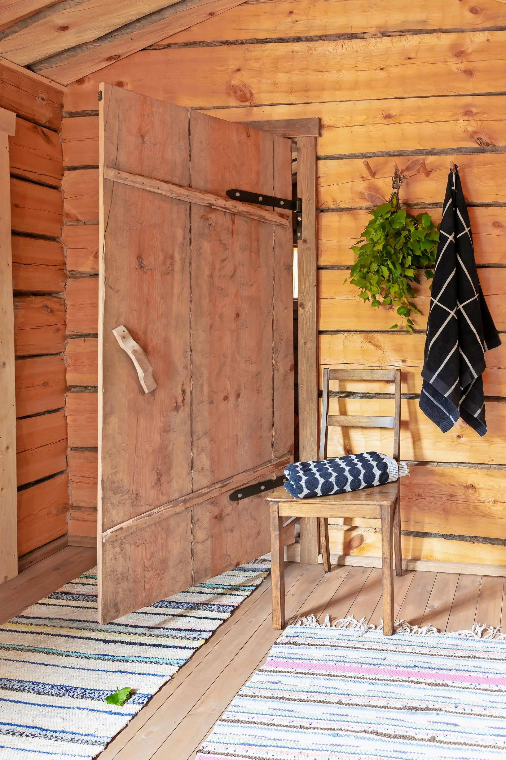 rag rugs, a chair, and a log wall