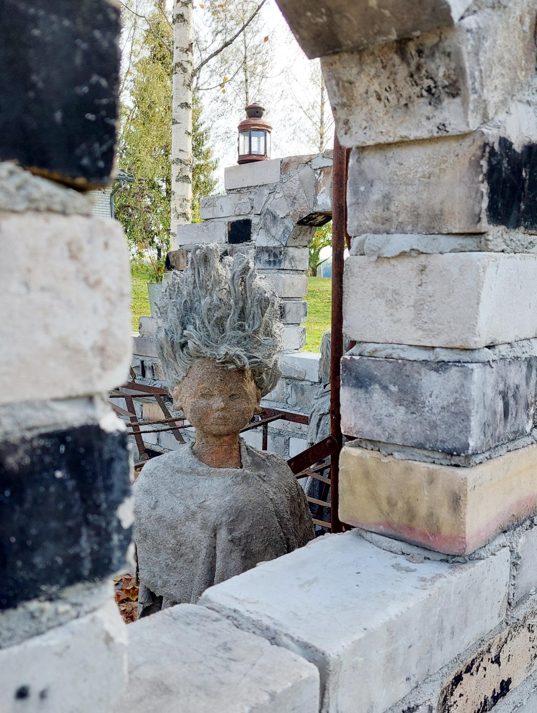 A ruin garden maiden peeking through an arched window.