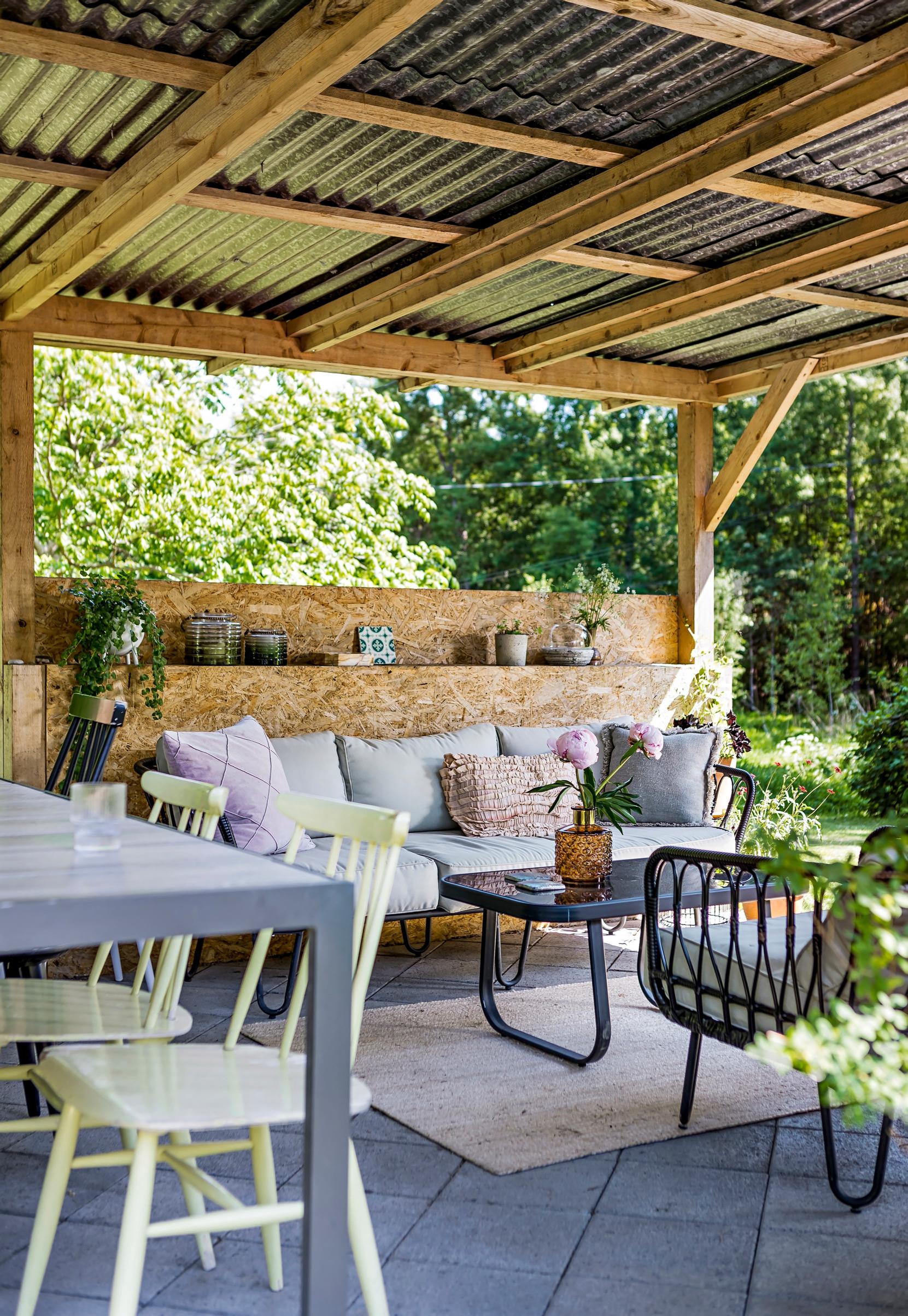 Walls and a roof built from OSB boards and corrugated sheets on the patio.