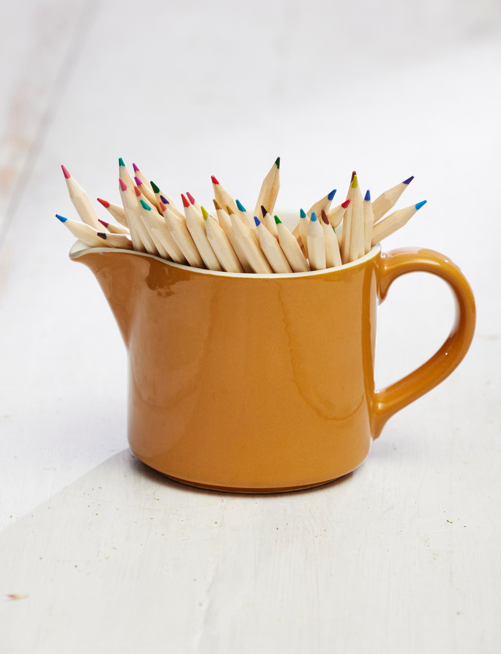 An old Arabia milk pitcher holding colored pencils.