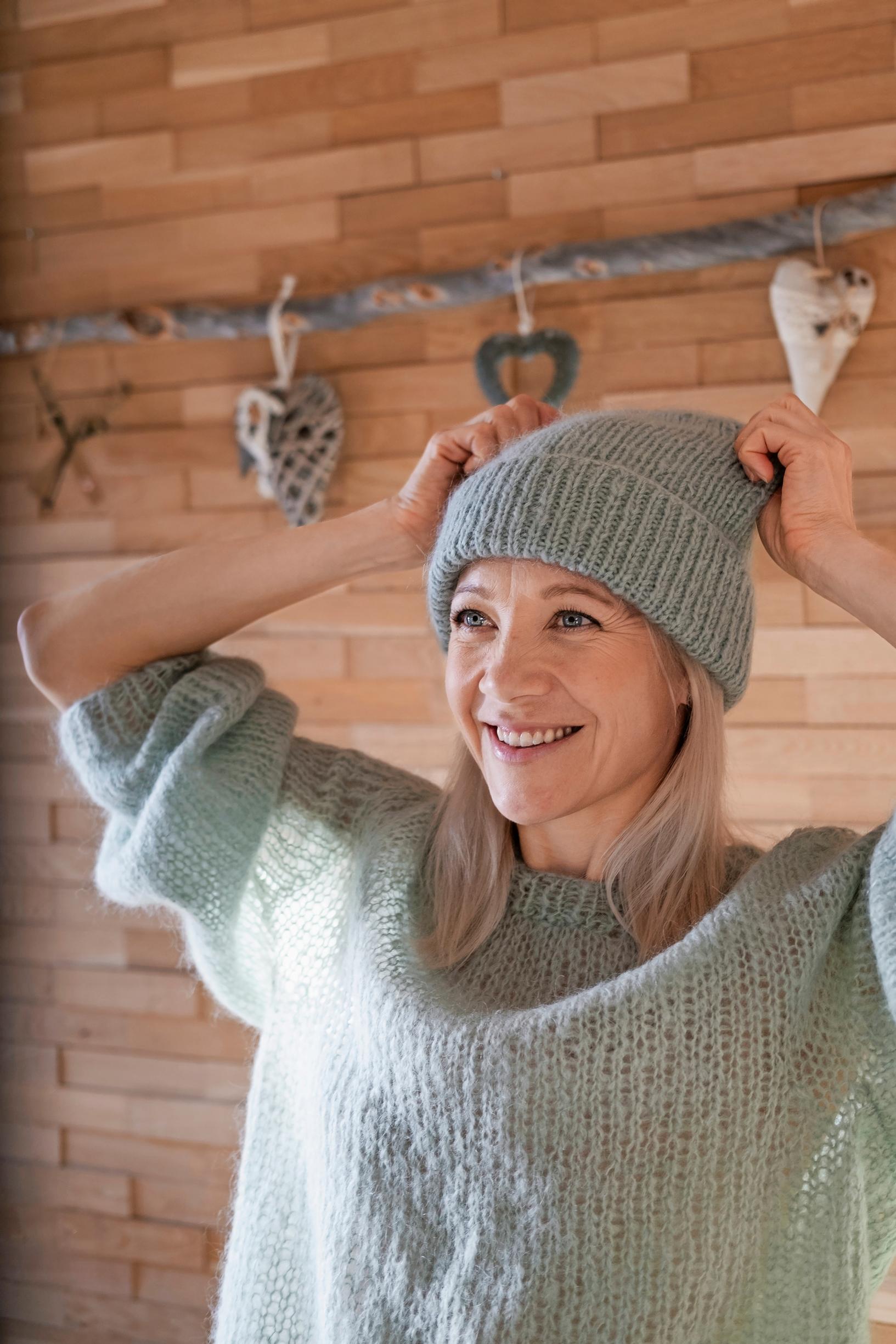 A pale turquoise sweater and beanie worn by Kaisa Mäkäräinen.