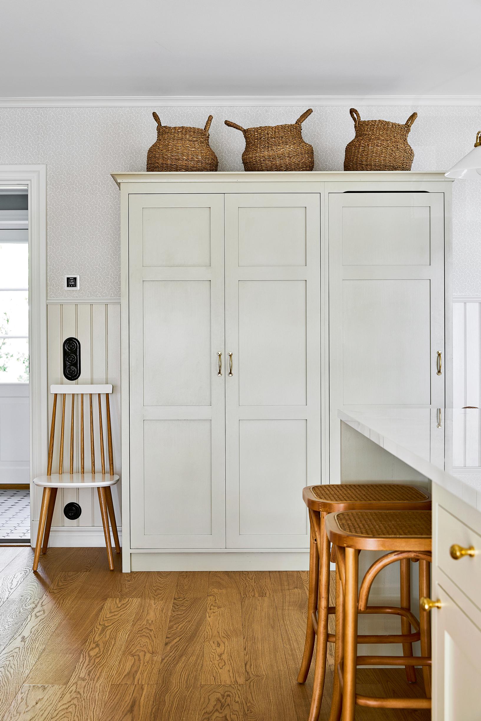 White, tall custom-made cabinet in the kitchen