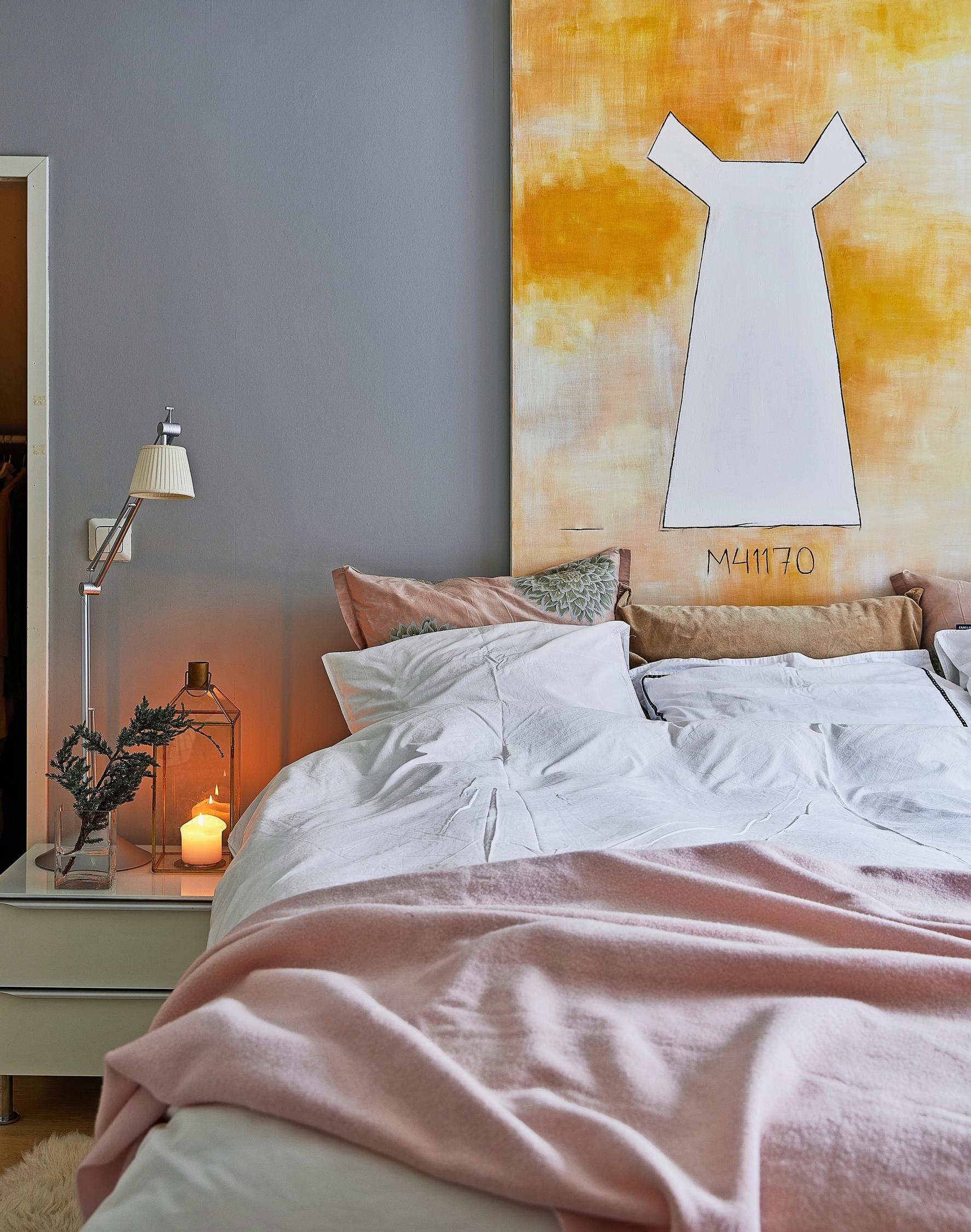 Bedroom with a painting on the wall above the bed