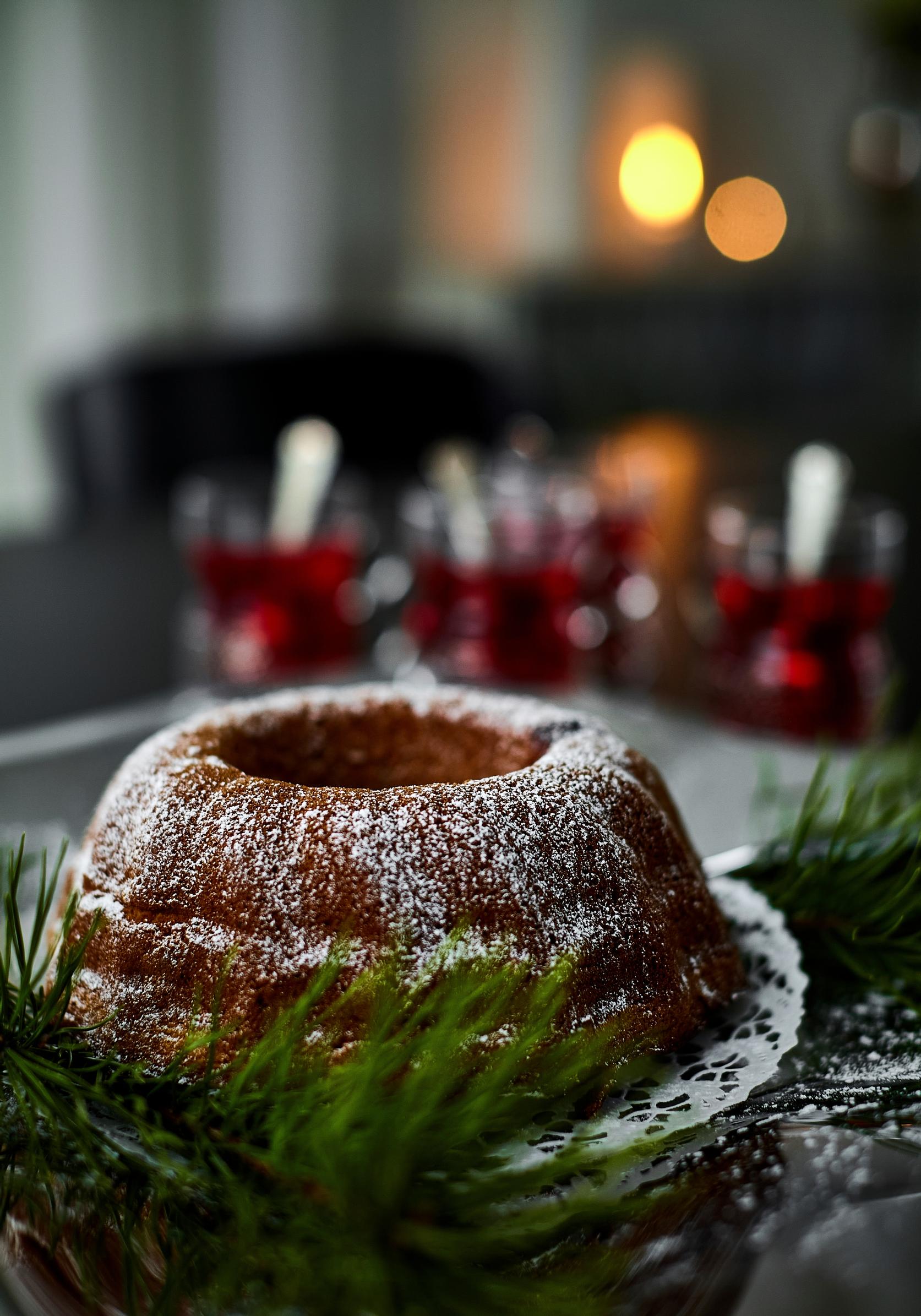 a festive bundt cake, conifer decoration, and mulled wine glasses in the background