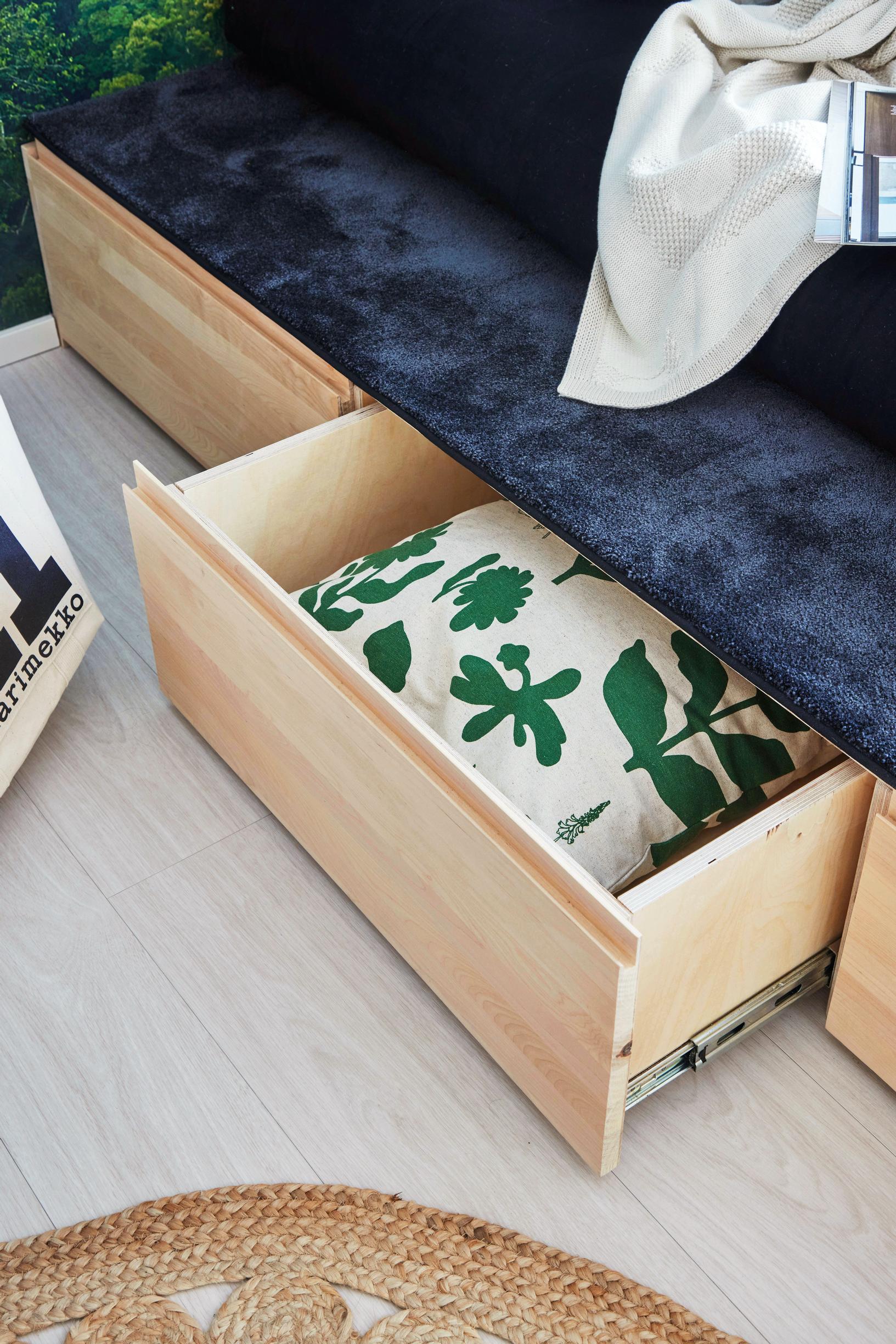 A pillow stored in a drawer built into the bed frame.