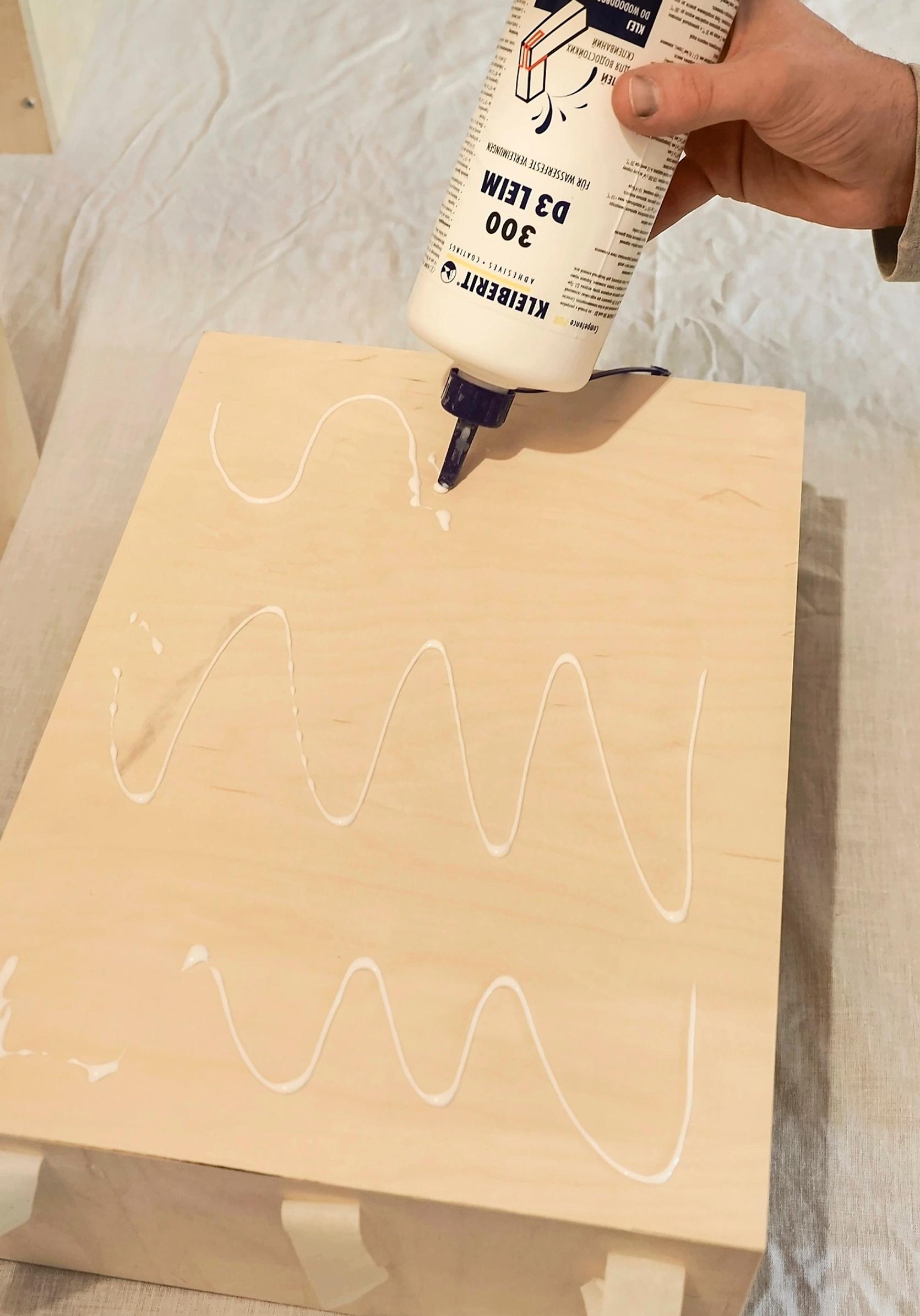 Gluing the bedside table’s top panel to the frame