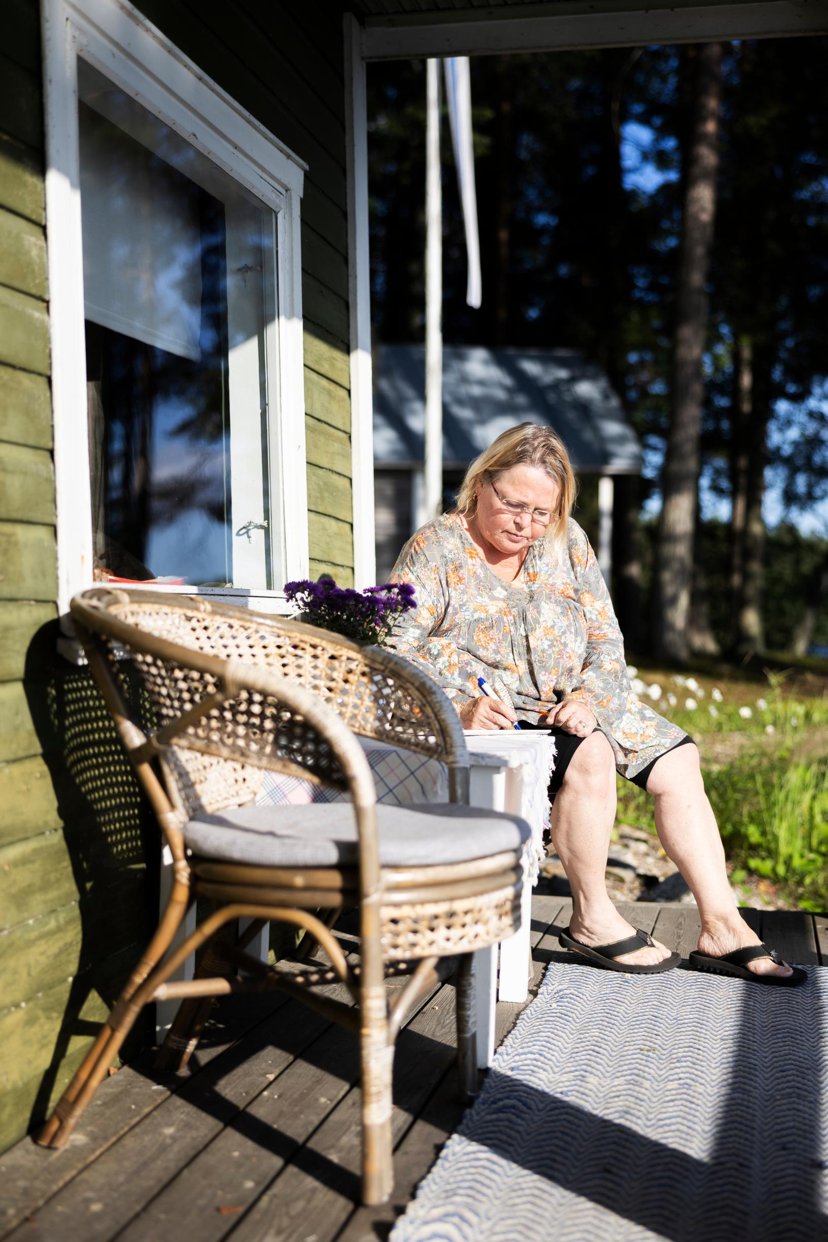 Helena sits on the terrace with a wicker chair in front