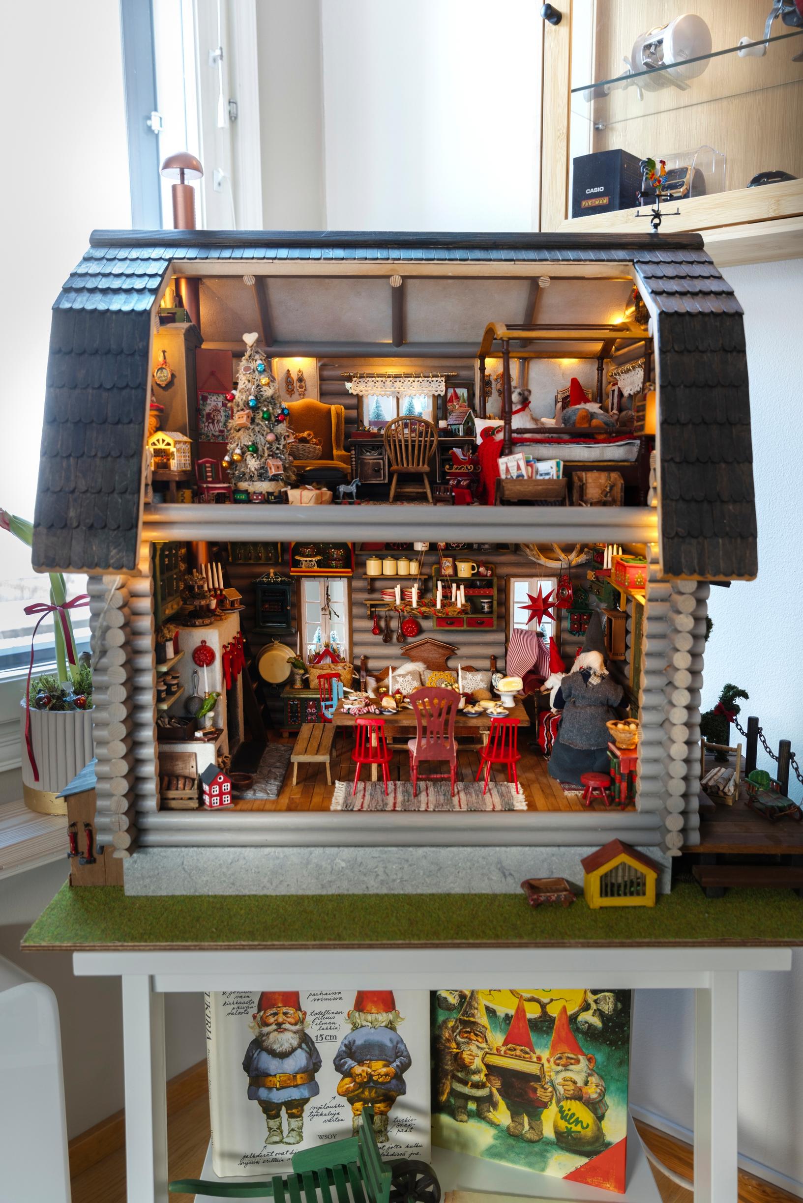 A home-made elf cottage, a Christmas-themed miniature log house, brimming with elves and accessories inside.