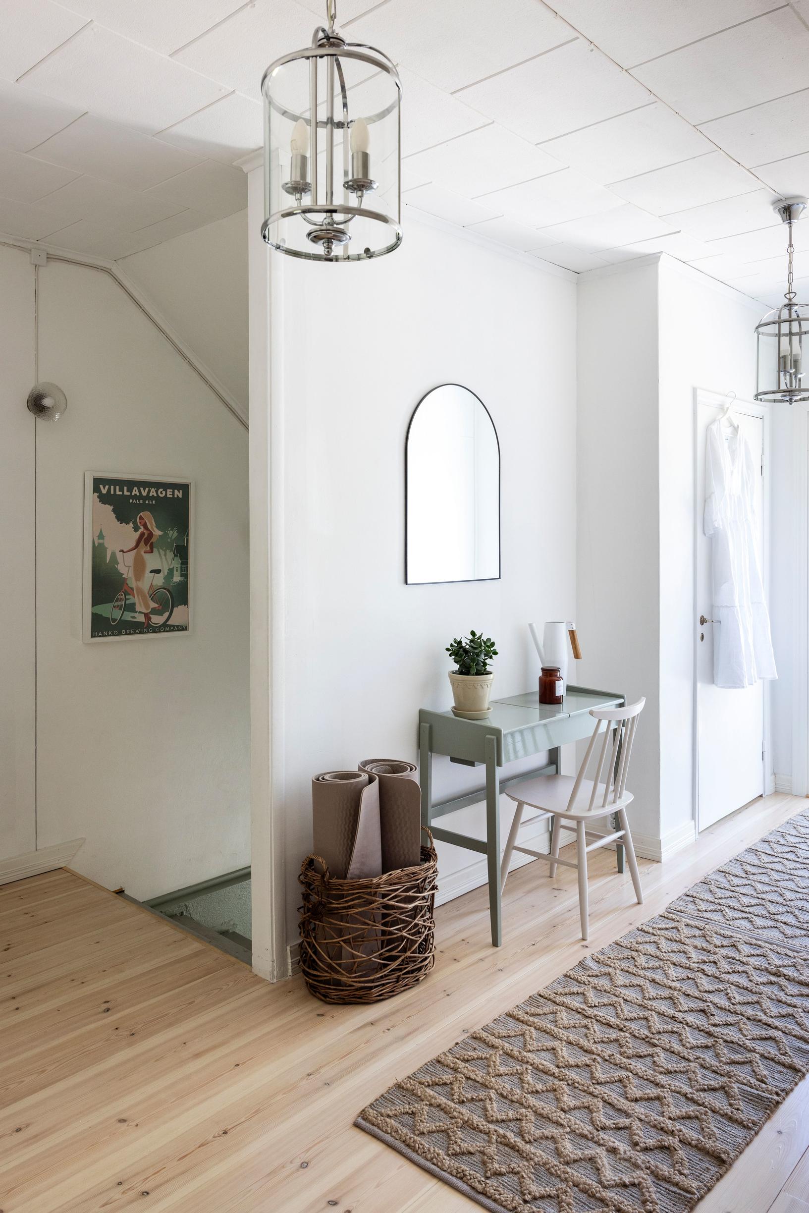 The room contains a desk and a partition wall, with stairs behind it leading downstairs.