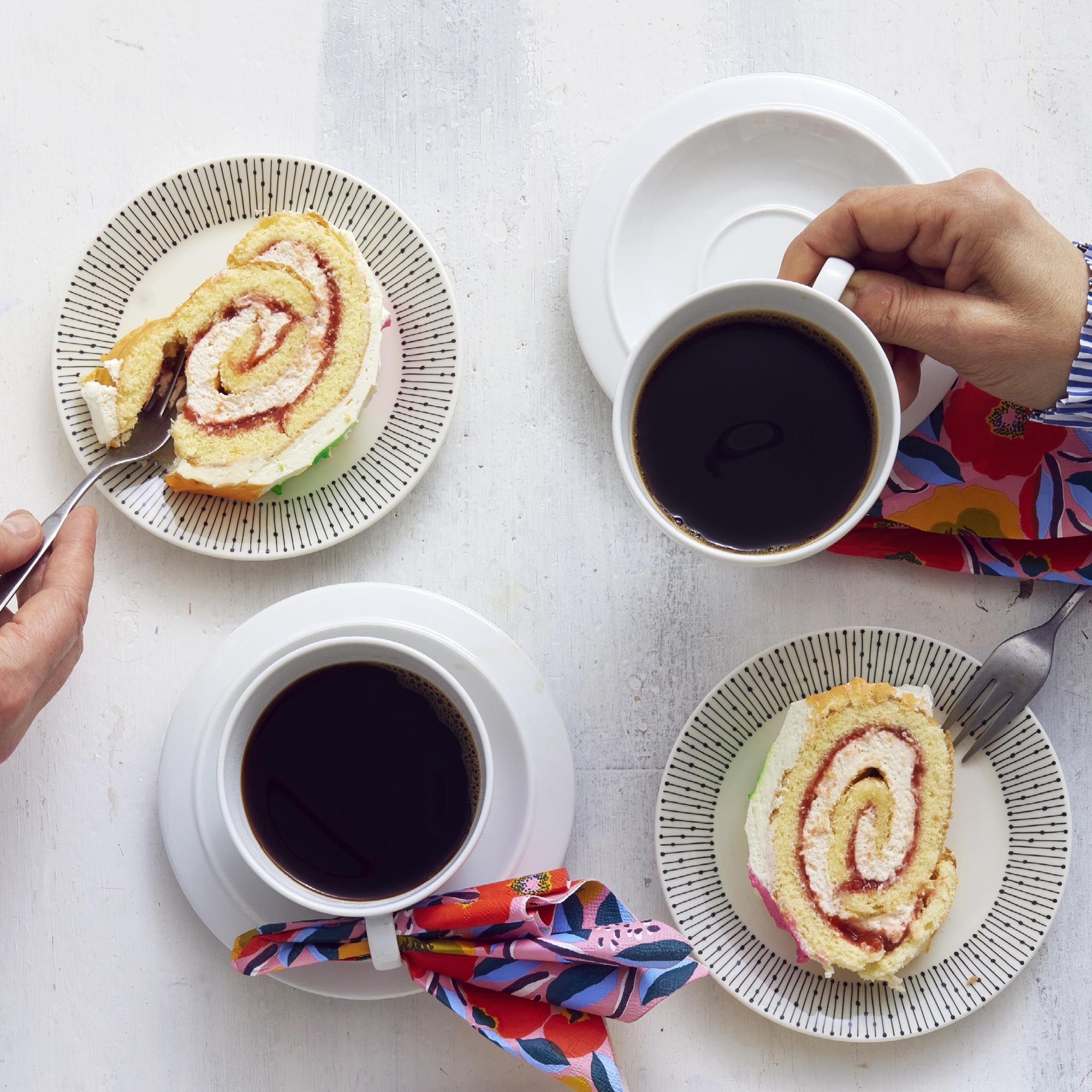 two cups of coffee and two slices of Swiss roll