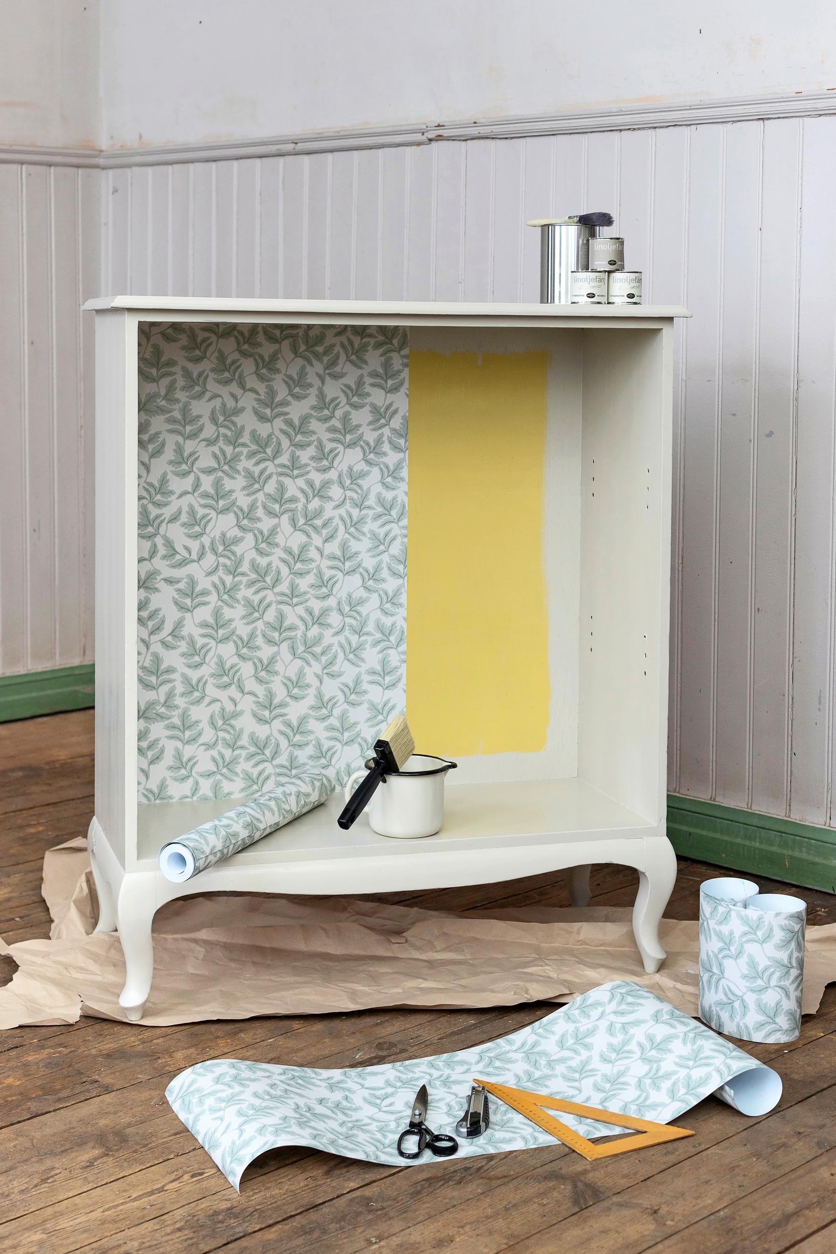 A vintage yellow open shelf is upcycled with wallpaper and linseed oil paint into a shoe shelf, step-by-step photo.