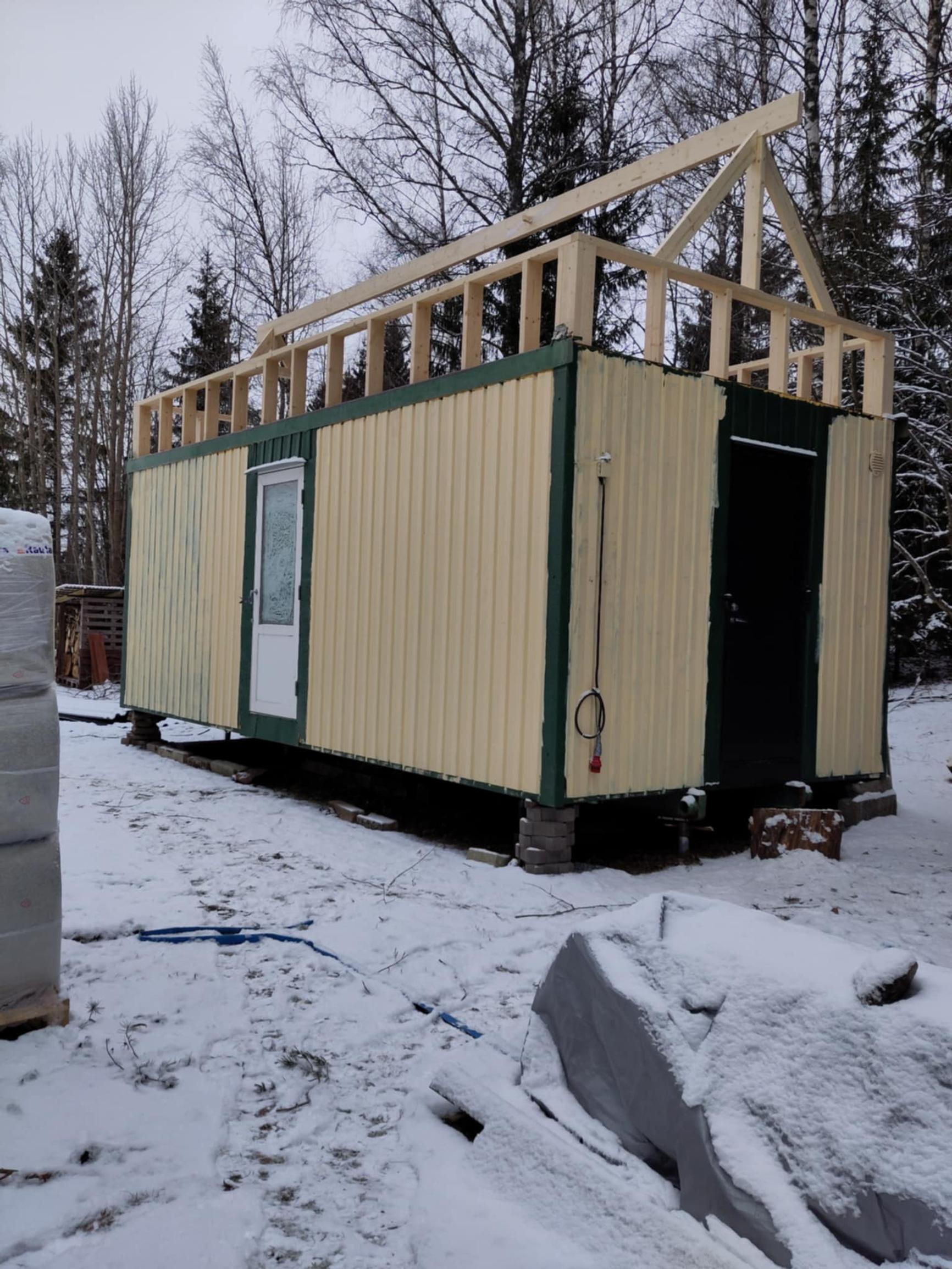 The steel container’s roof has been removed and a raised section with a gable roof built on top.