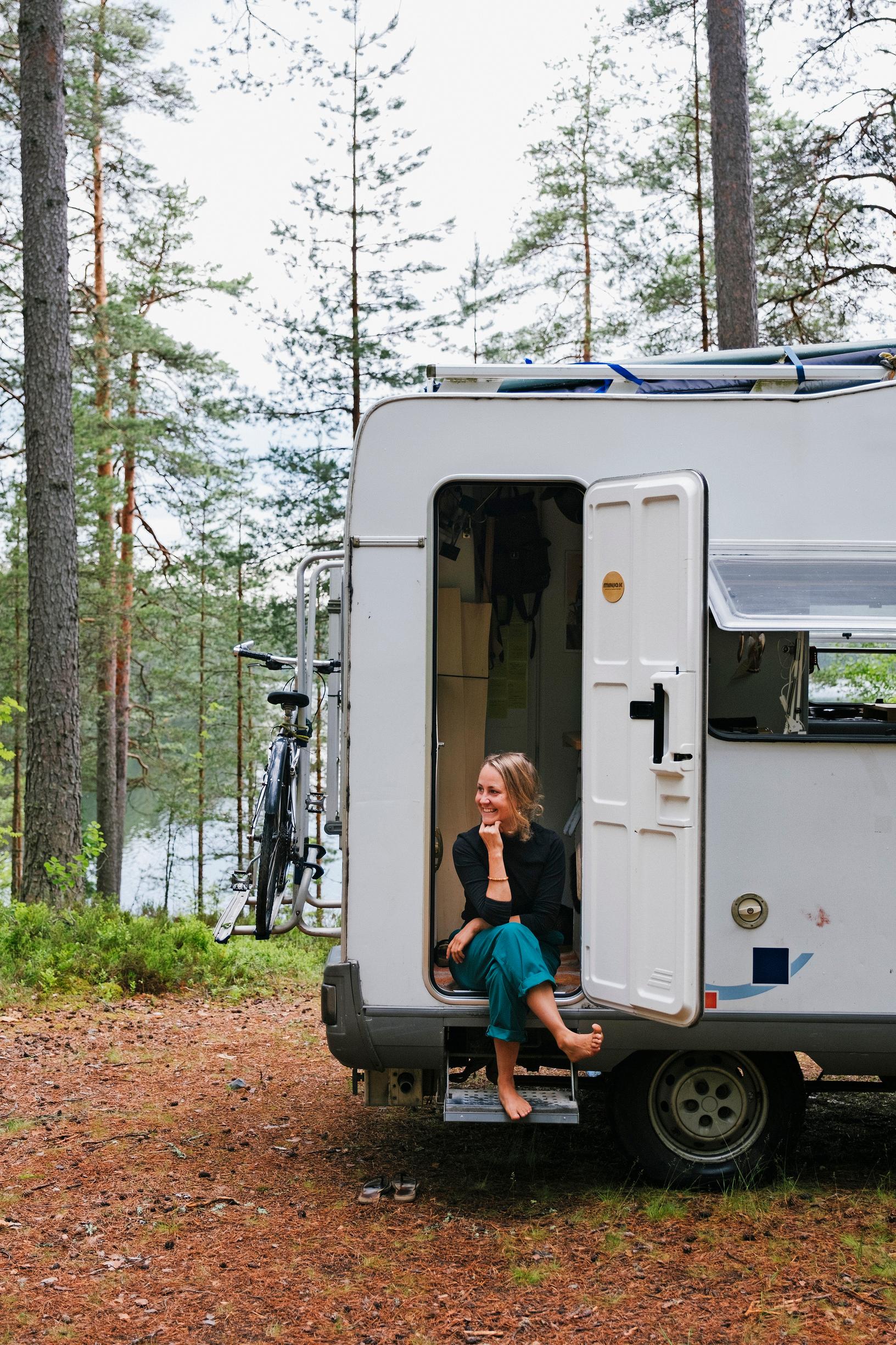 A woman sitting in the doorway of a motorhome