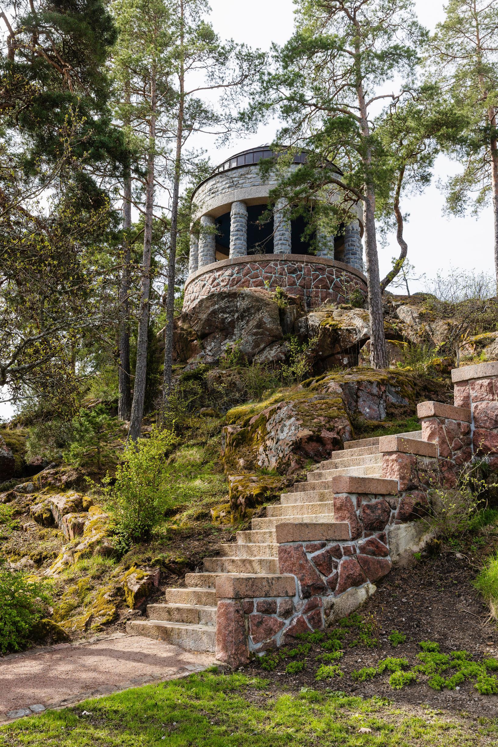 A stone pavilion on a slope with steps leading up to it