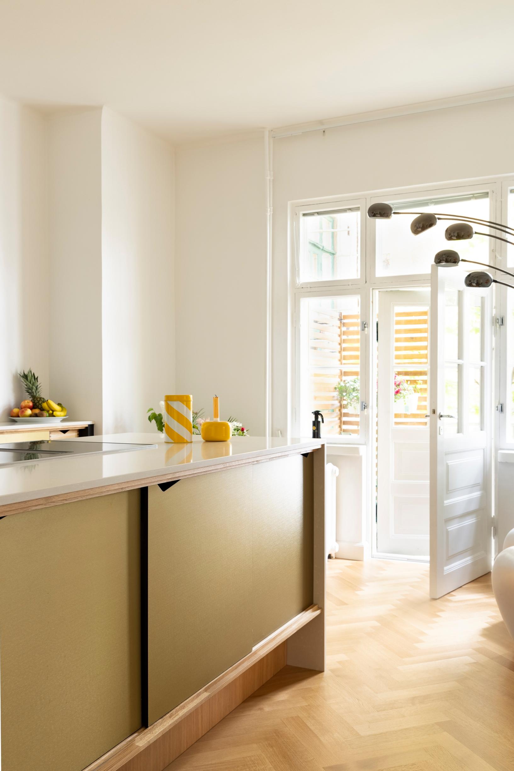 Yellowish kitchen cabinets and a door to the balcony