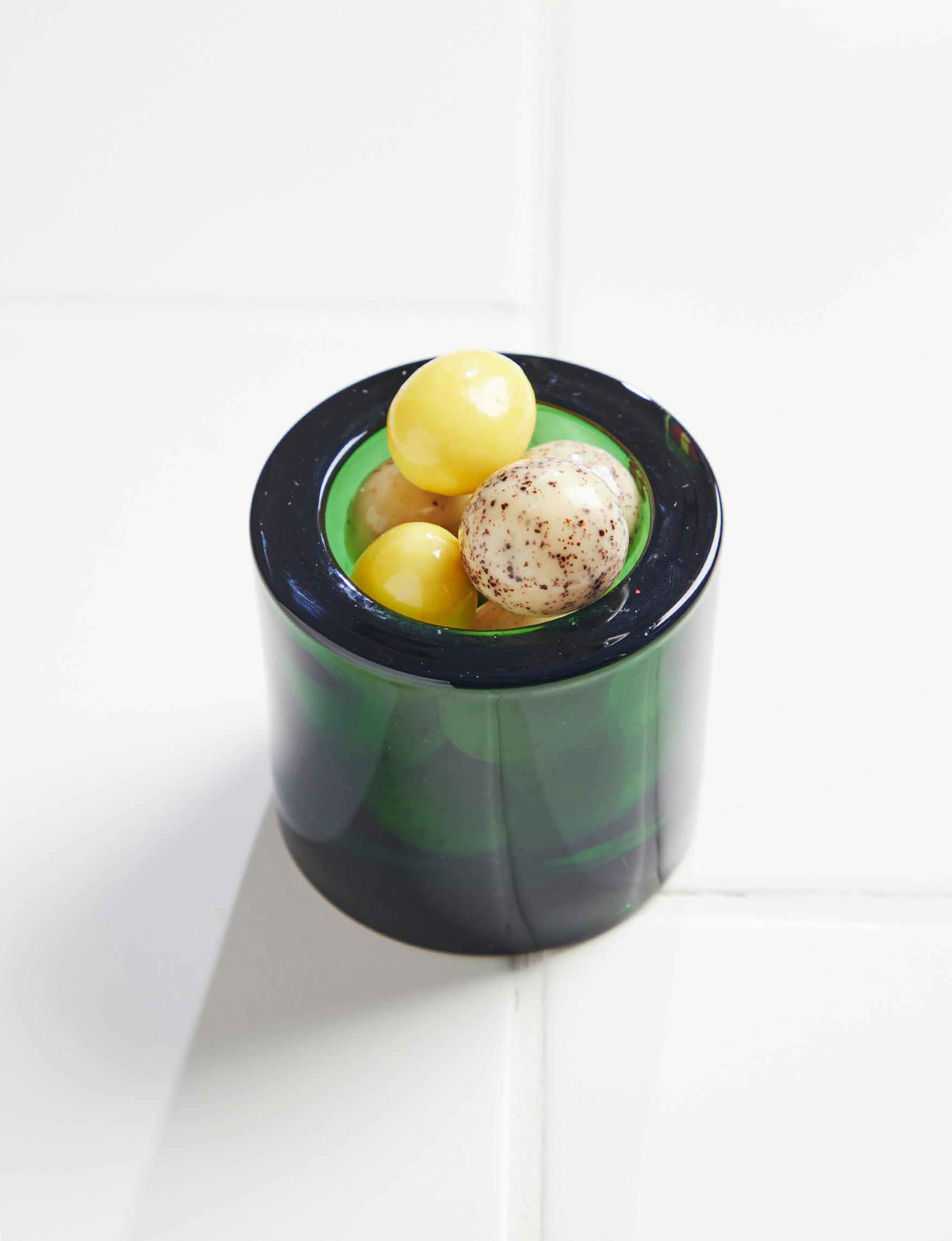 A Kivi tea light holder filled with candies.