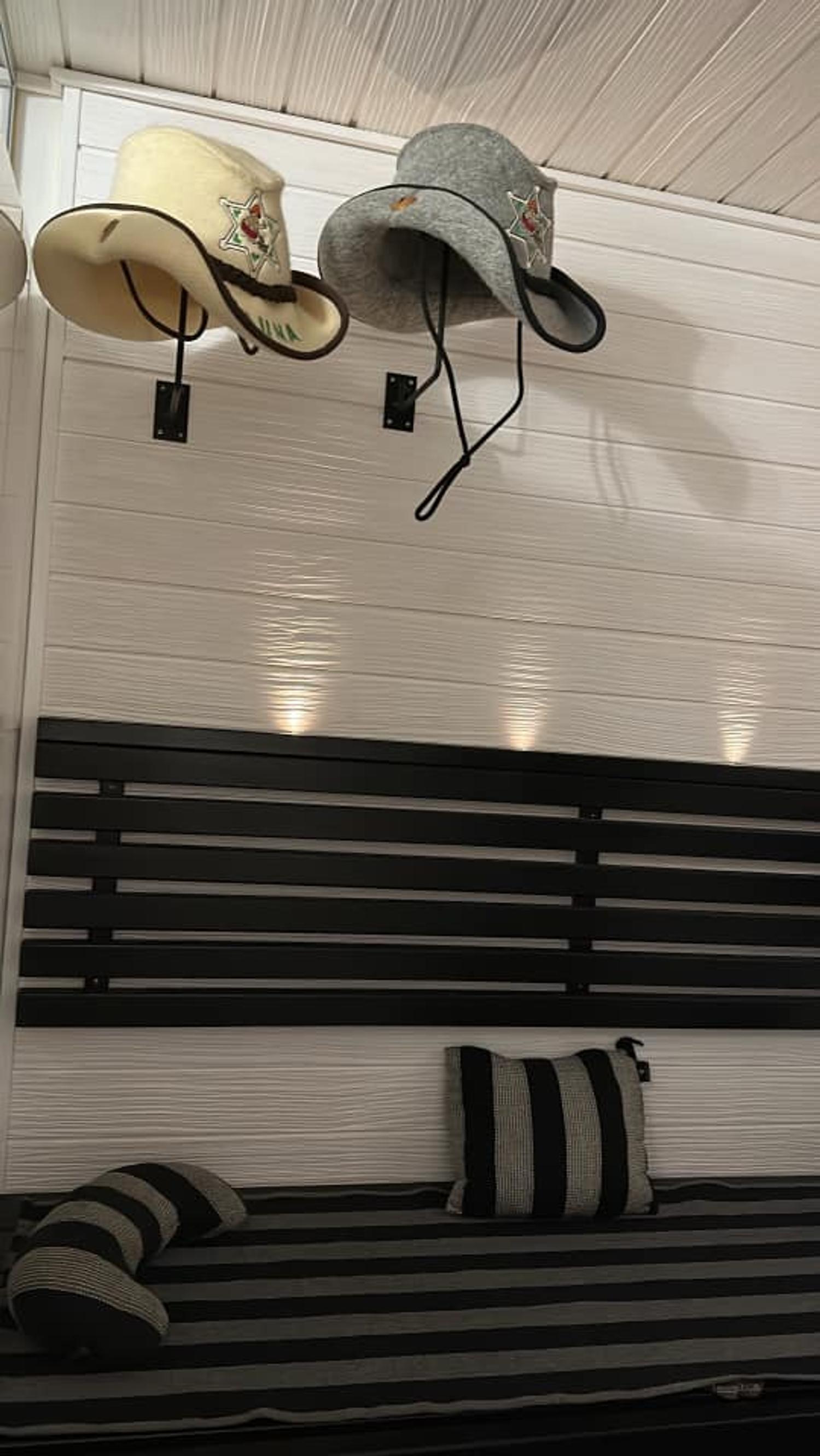 Cowboy-style hats hanging on a sauna wall.
