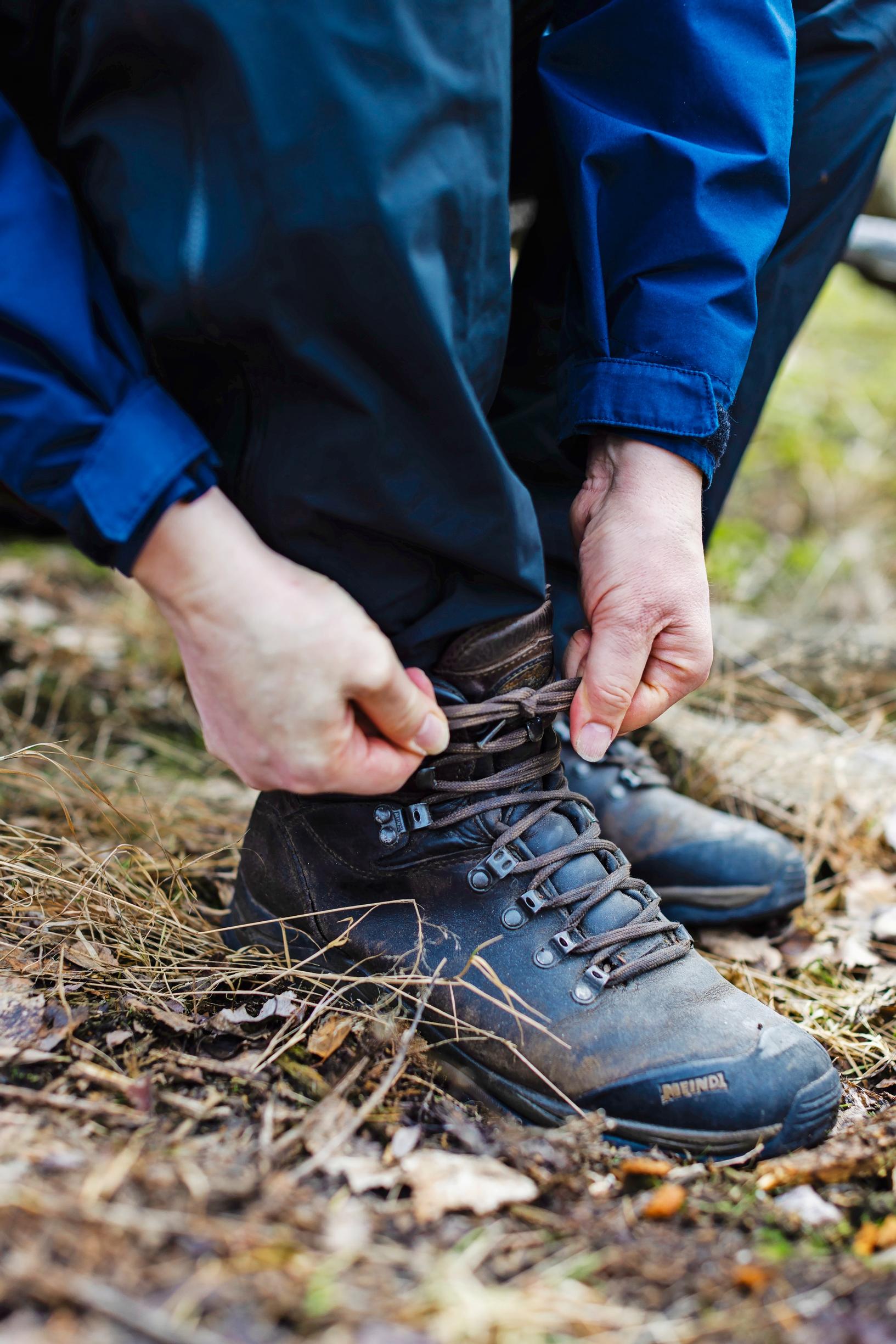 hands tying the laces of a hiking boot