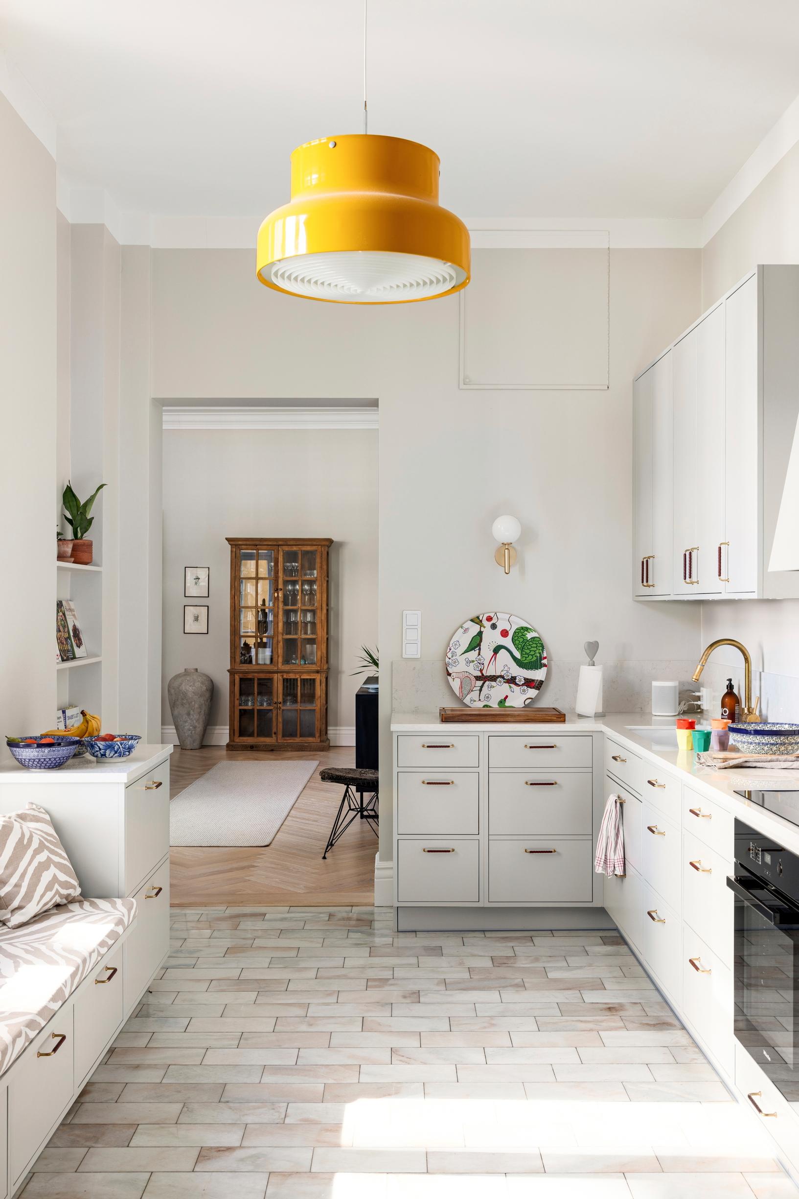 A widened doorway, marble floors, light built-in cabinets, and a Bumling lamp in the kitchen.