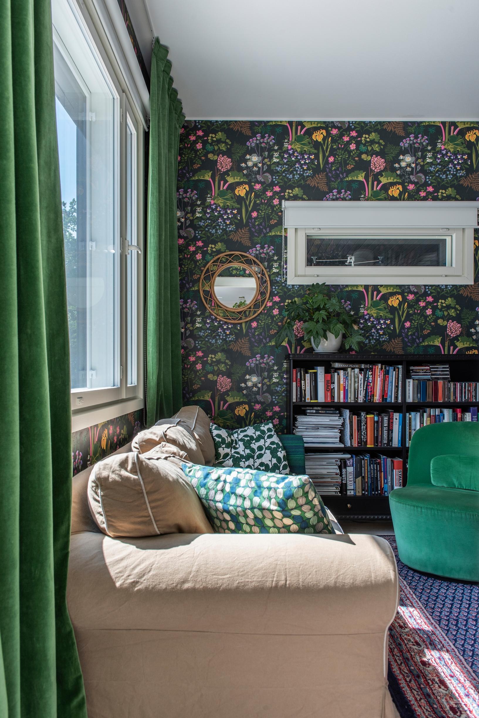 A velvet curtain in the living room, matched with the patterned wallpaper's palette