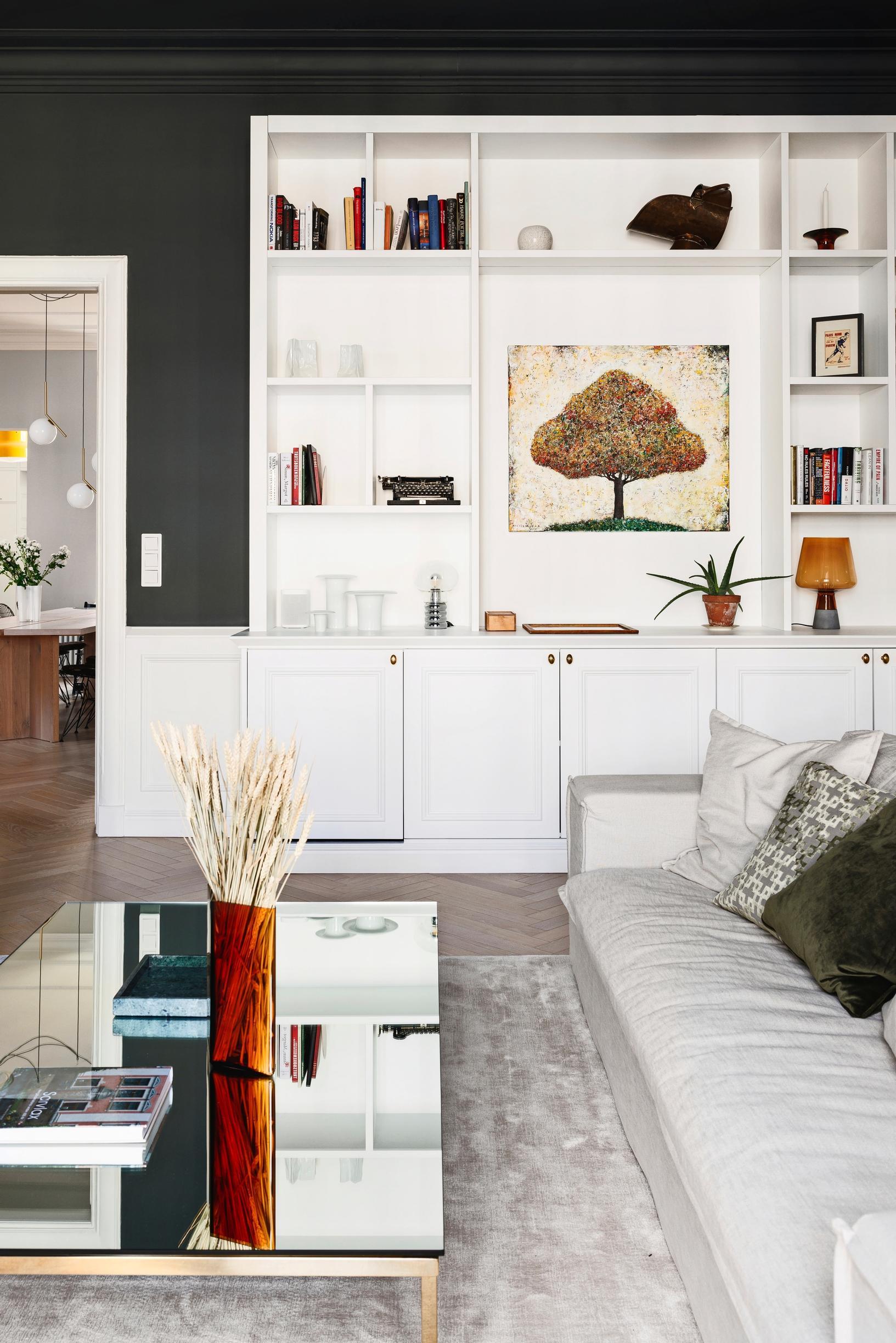 Custom-made wall paneling in front of a dark-painted wall and a white bookshelf.